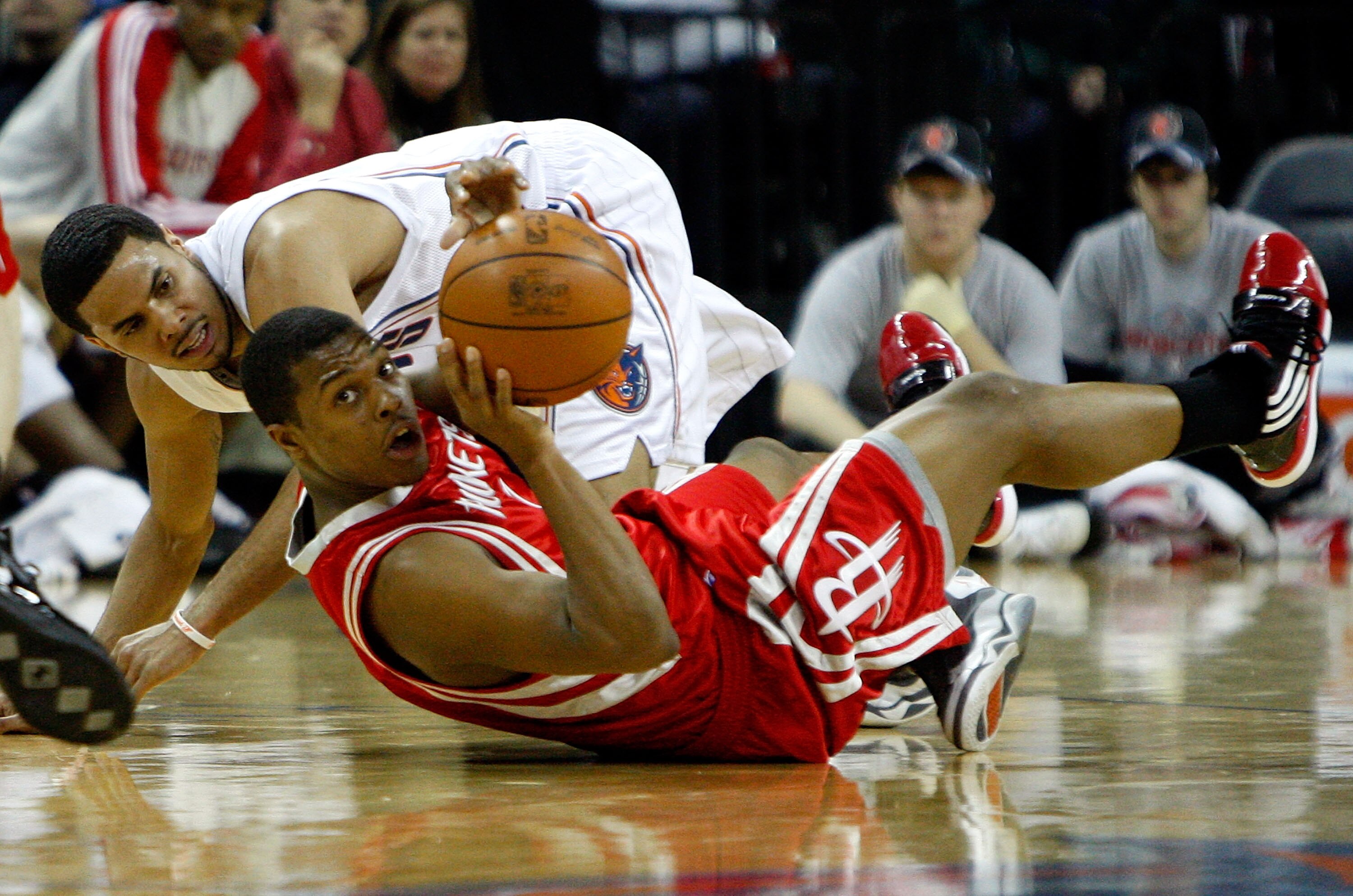 CHARLOTTE, NC - JANUARY 12:  Kyle Lowry #7 of the Houston Rockets scrambles for a loose ball with D.J. Augustin #14 of the Charlotte Bobcats at Time Warner Cable Arena on January 12, 2010 in Charlotte, North Carolina.  NOTE TO USER: User expressly acknowl