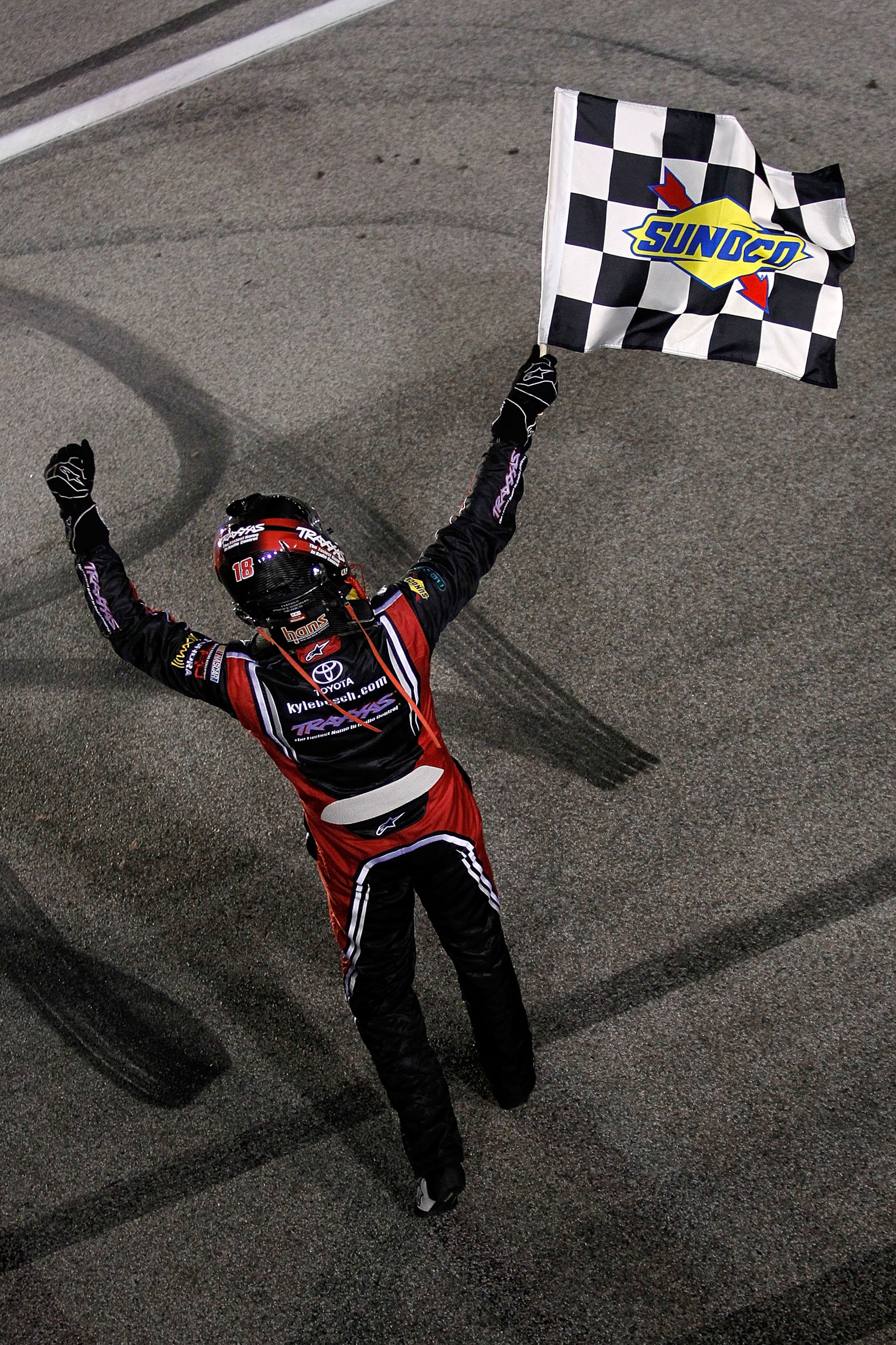 HOMESTEAD, FL - NOVEMBER 19:  Kyle Busch, driver of the #18 Toyota Tundra/TRAXXAS Toyota, celebrates with the checkered flag after winning the NASCAR Camping World Truck Series Ford 200 at Homestead-Miami Speedway on November 19, 2010 in Homestead, Florid