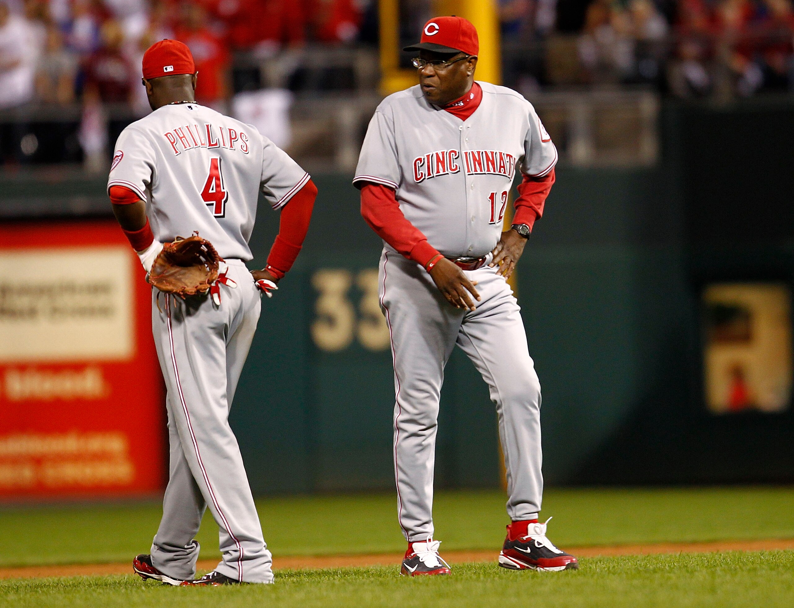 PHILADELPHIA - OCTOBER 08:  Dusty Baker #12 talks with Brandon Phillips #4 of the Cincinnati Reds in Game 2 of the NLDS against the Philadelphia Phillies at Citizens Bank Park on October 8, 2010 in Philadelphia, Pennsylvania.  (Photo by Jeff Zelevansky/Ge