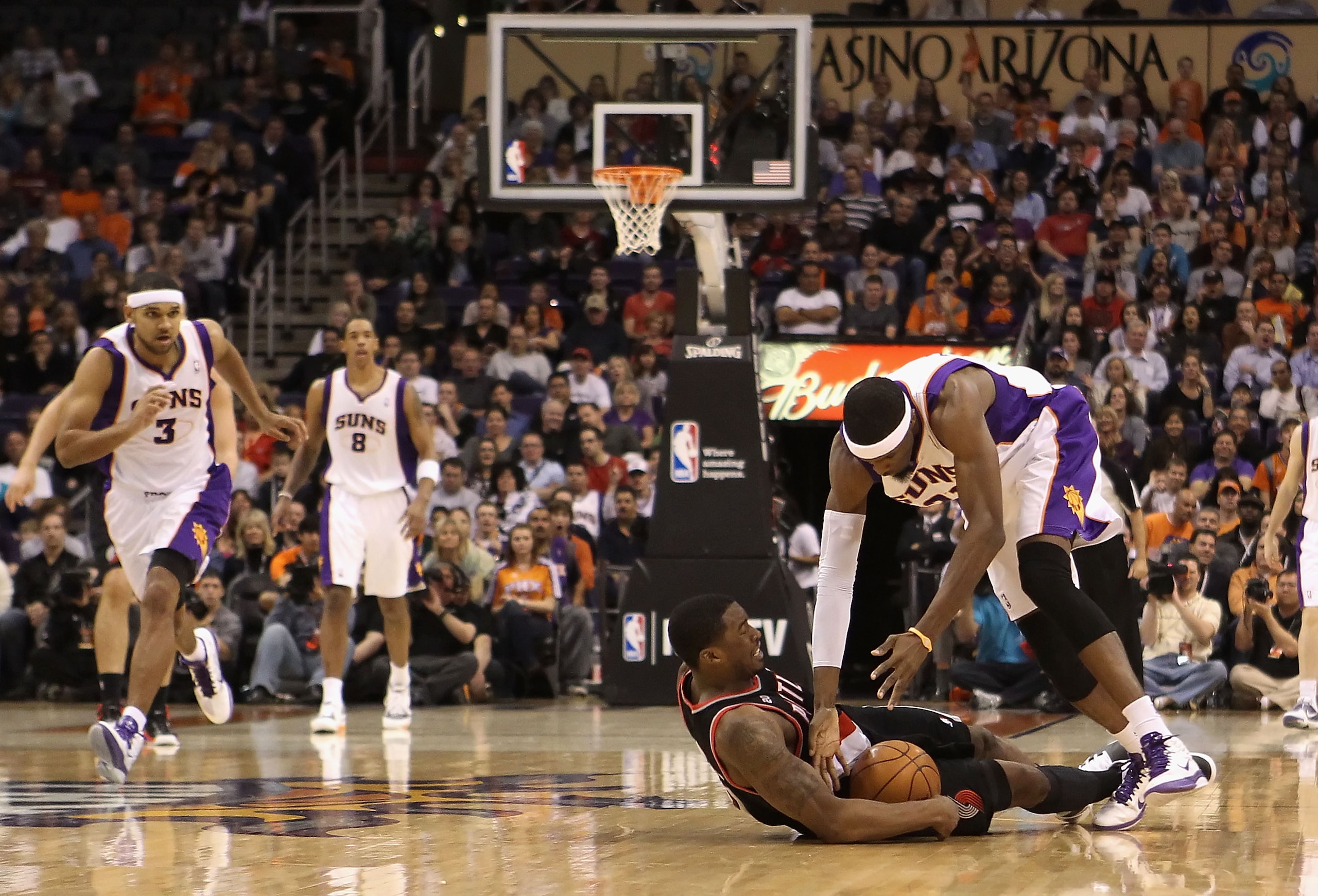 PHOENIX, AZ - JANUARY 14:  Hakim Warrick #21 of the Phoenix Suns dives for a loose ball with Wesley Matthews #2 of the Portland Trail Blazers during the NBA game at US Airways Center on January 14, 2011 in Phoenix, Arizona. The Suns defeated the Trail Bla