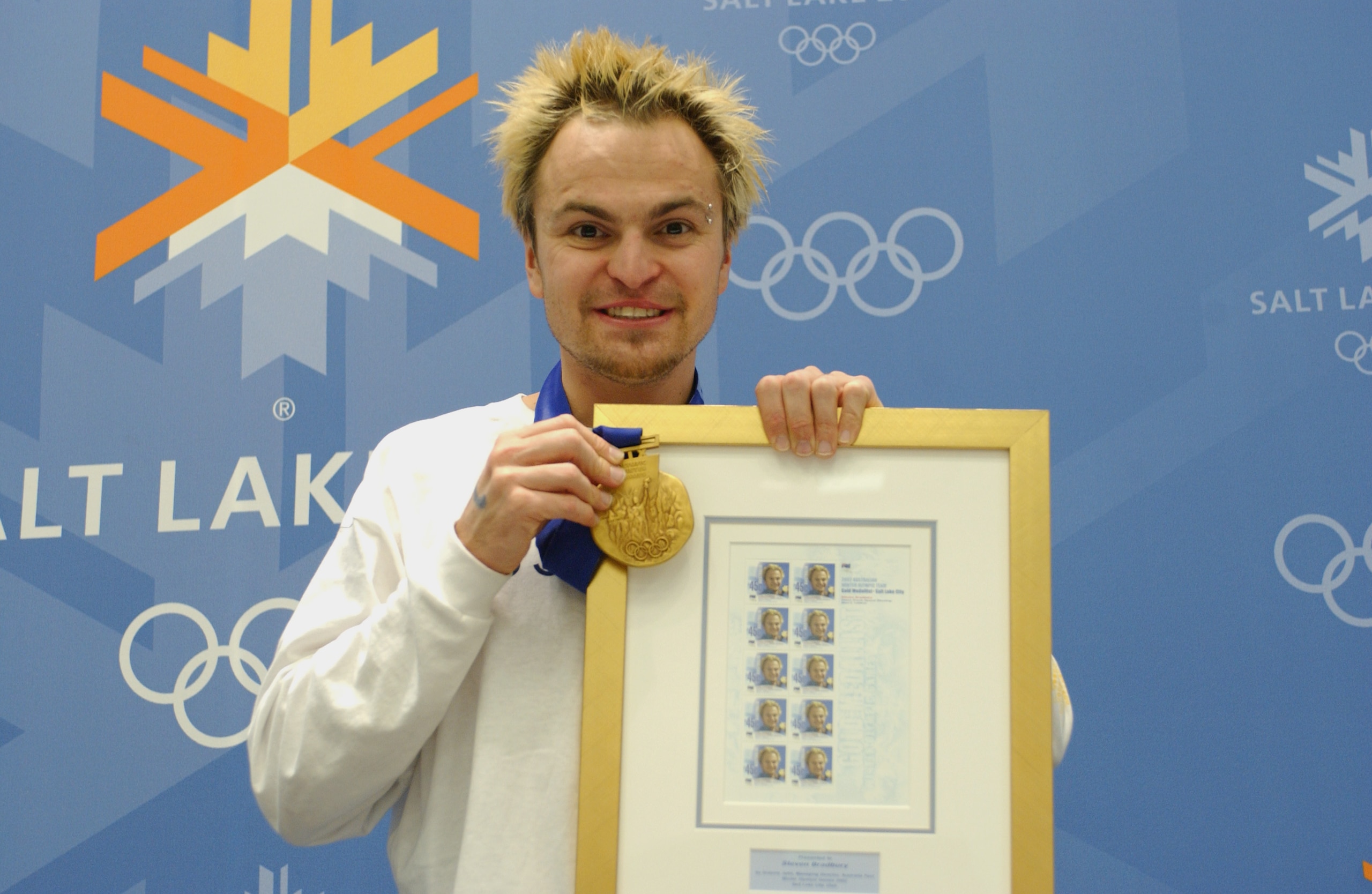 SALT LAKE CITY, UT - FEBRUARY 24:  Steven Bradbury, one of Australia's two gold medalists, poses with his commemorative stamps and gold medal during the Australian Press Conference at the Main Media Center on February 24, 2002 during the Salt Lake Winter