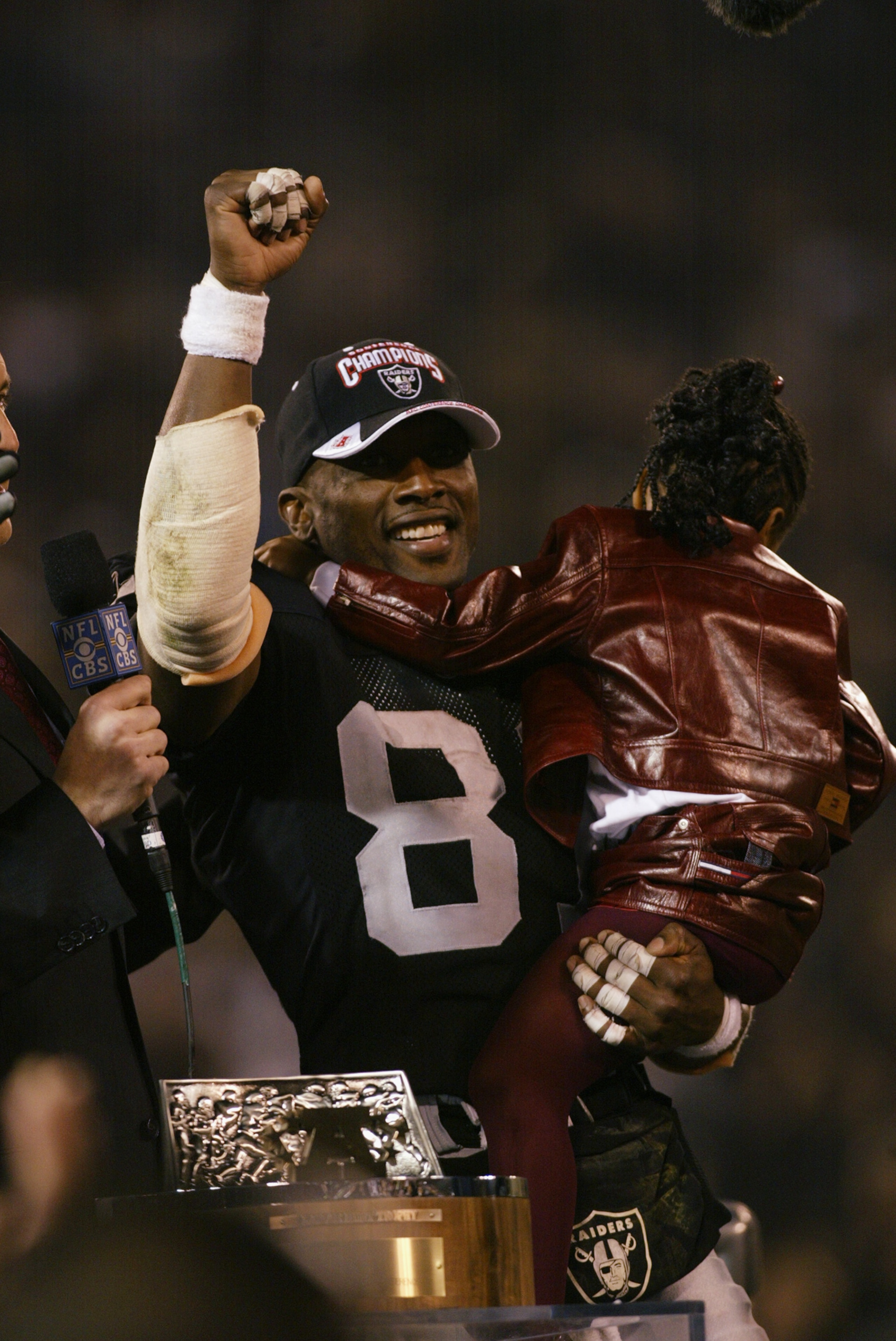OAKLAND, CA - JANUARY 19:  Wide receiver Tim Brown #81 of the Oakland Raiders gives a victory salute from the podium during the ceremonies after the 41-24 victory over the Tennessee Titans in the AFC Championship game at Network Associates Coliseum on Jan