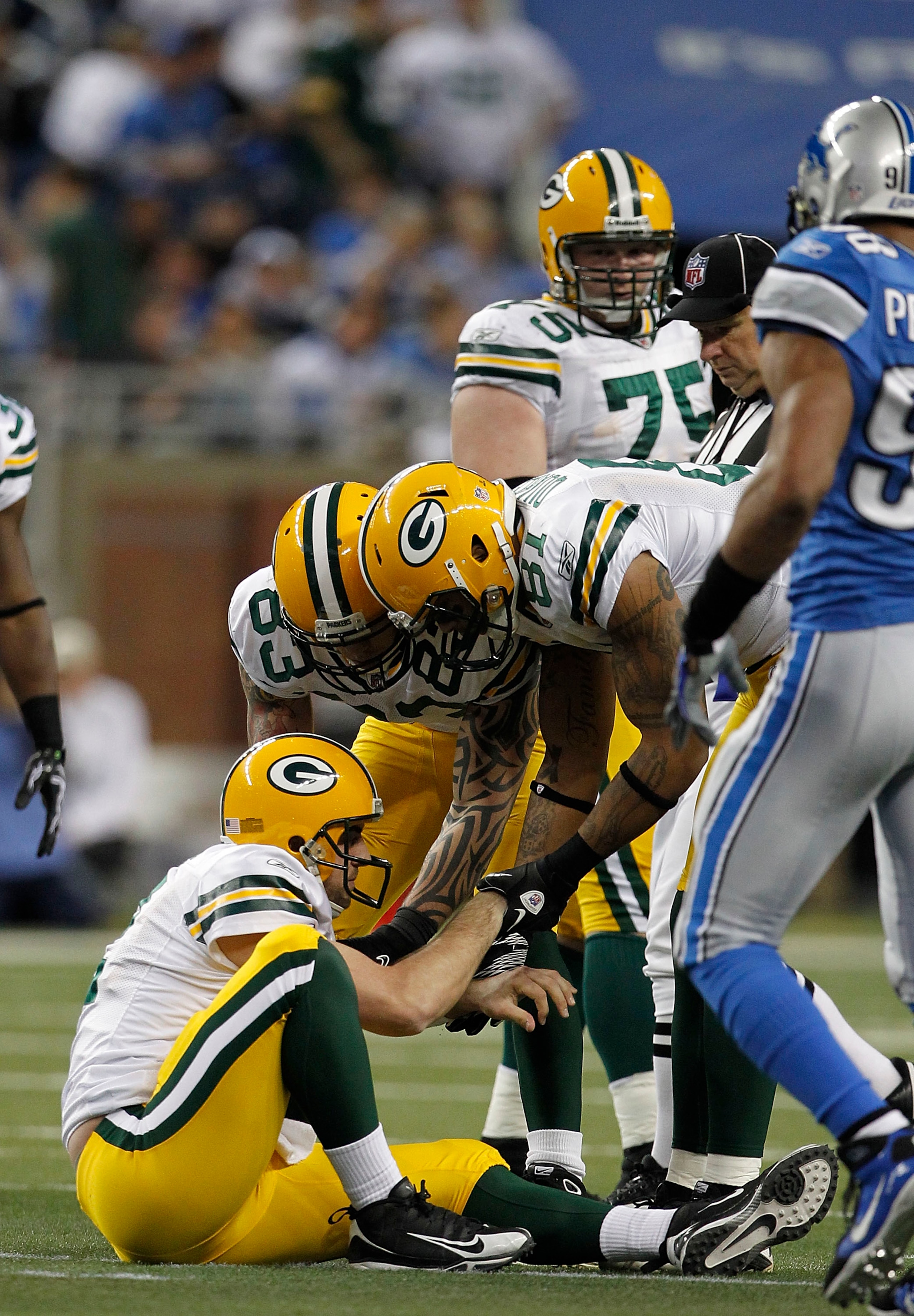 DETROIT - DECEMBER 12: Andrew Quarless #81 and Tom Crabtree #83 of the Green Bay Packers helps Aaron Rogers #12 of the Green Bay Packers up during the second quarter of the game against the Detroit Lions at Ford Field on December 12, 2010 in Detroit, Mich