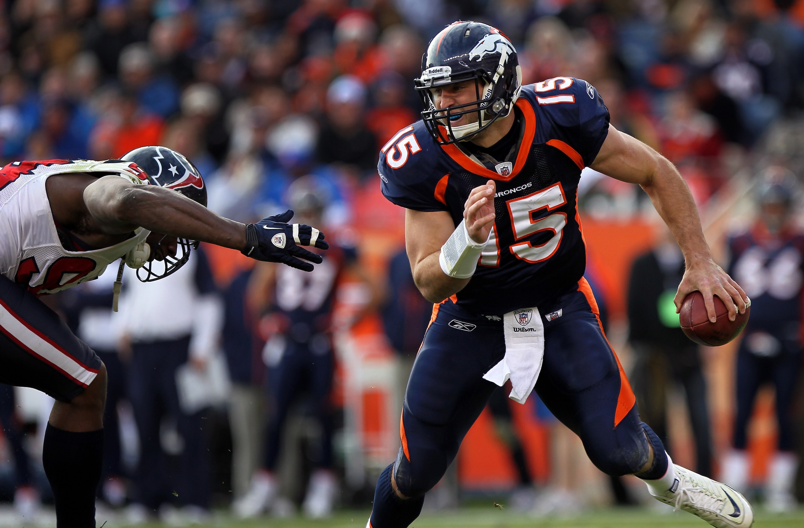 DENVER - DECEMBER 26: Quarterback Tim Tebow #15 of the Denver Broncos rolls out and looks to deliver a pass against the Houston Texas at INVESCO Field at Mile High on December 26, 2010 in Denver, Colorado. The Broncos defeated the Texans 24-23. (Photo b DENVER - DECEMBER 26: Quarterback Tim Tebow #15 of the Denver Broncos rolls out and looks to deliver a pass against the Houston Texas at INVESCO Field at Mile High on December 26, 2010 in Denver, Colorado. The Broncos defeated the Texans 24-23. (Photo b