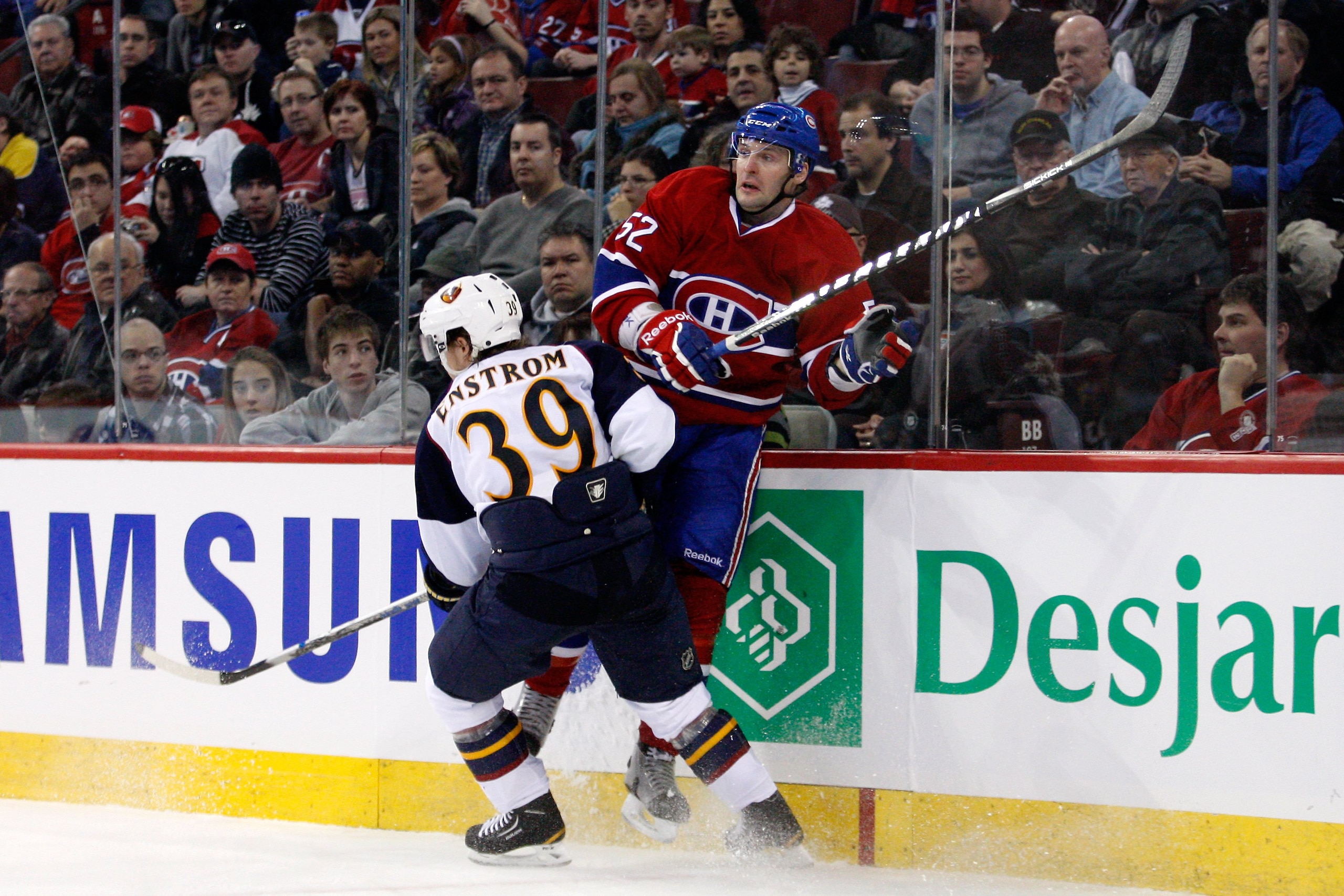 MONTREAL, CANADA - JANUARY 2:  Tobias Enstrom #39 of the Atlanta Thrashers body checks Mathieu Darche #52 of the Montreal Canadiens during the NHL game at the Bell Centre on January 2, 2011 in Montreal, Quebec, Canada.  The Thrashers defeated the Canadien
