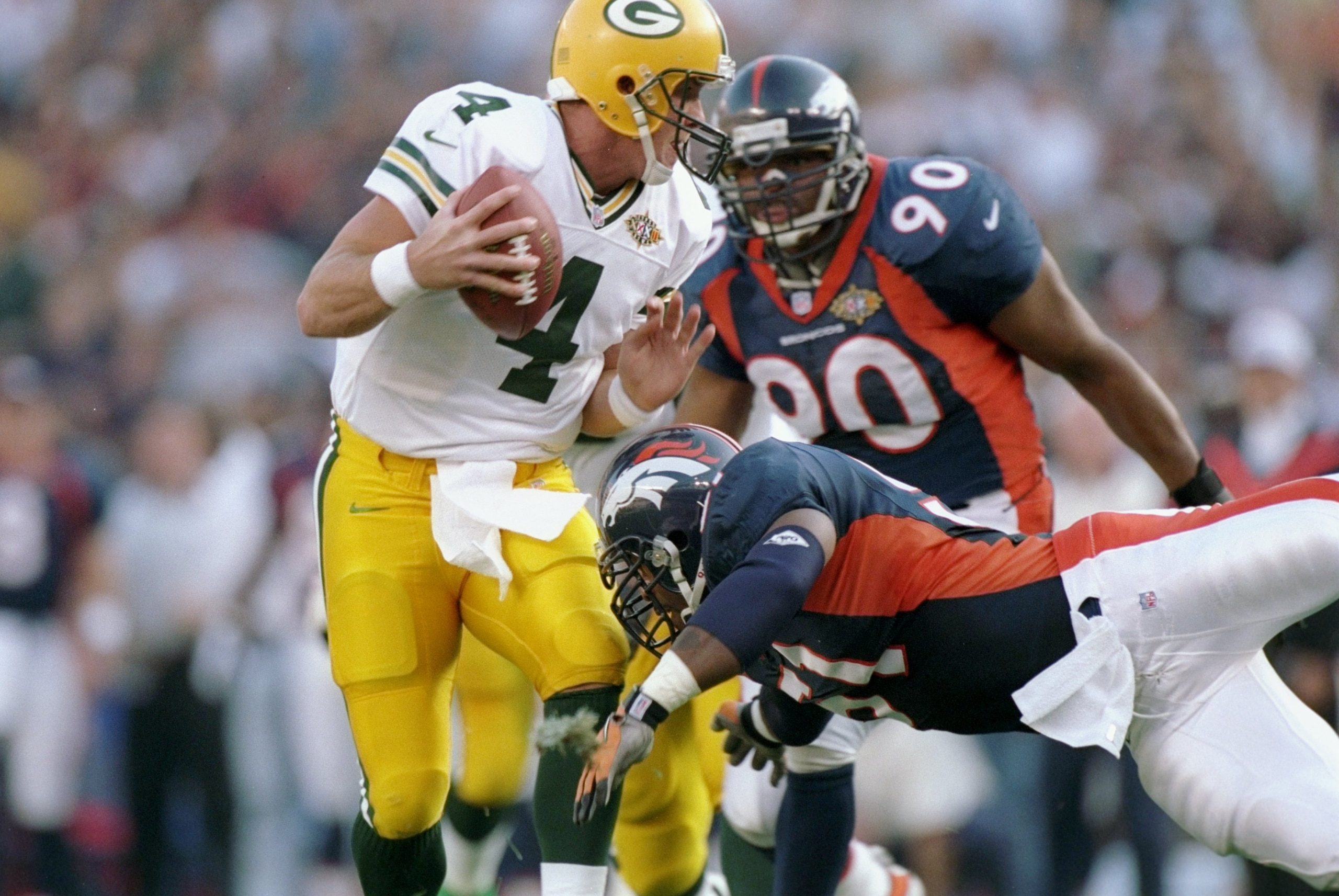 25 Jan 1998:  Brett Favre #4 of the Green Bay Packers avoids being sacked by John Mobley #51 and Neil Smith #90 of the Denver Broncos during Super Bowl  XXXII at Qualcomm Stadium in San Diego, California.  The Denver Broncos defeated the Green Bay Packers