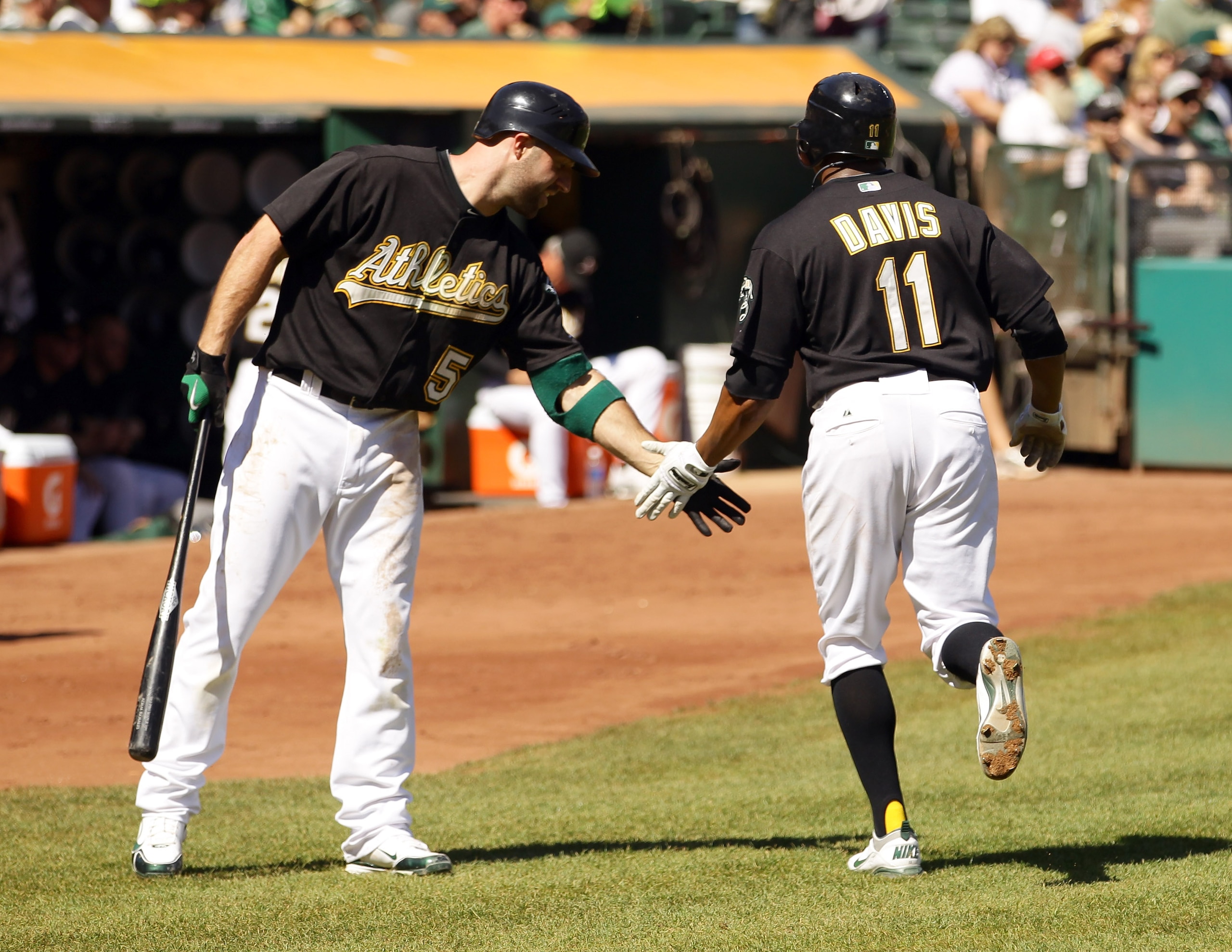 OAKLAND, CA - SEPTEMBER 25: Rajai Davis #11 of the Oakland Athletics is congratulated by Kevin Kouzmanoff #5 after Davis scored in the first inning to give the Athletics a 1-0 lead over the Texas Rangers at the Oakland-Alameda County Coliseum on Septembe OAKLAND, CA - SEPTEMBER 25: Rajai Davis #11 of the Oakland Athletics is congratulated by Kevin Kouzmanoff #5 after Davis scored in the first inning to give the Athletics a 1-0 lead over the Texas Rangers at the Oakland-Alameda County Coliseum on Septembe