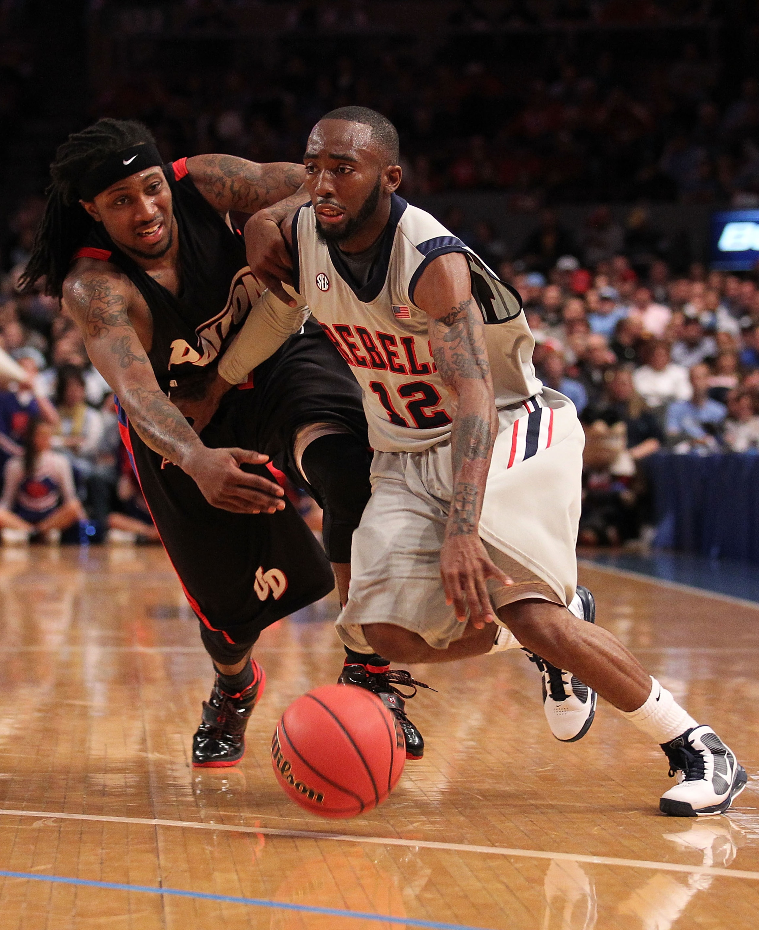 NEW YORK - MARCH 30:  Chris Warren #12 of Ole Miss drives past London Warren #1 of the Dayton Flyers during their semi final at Madison Square Garden on March 30, 2010 in New York, New York.  (Photo by Nick Laham/Getty Images)
