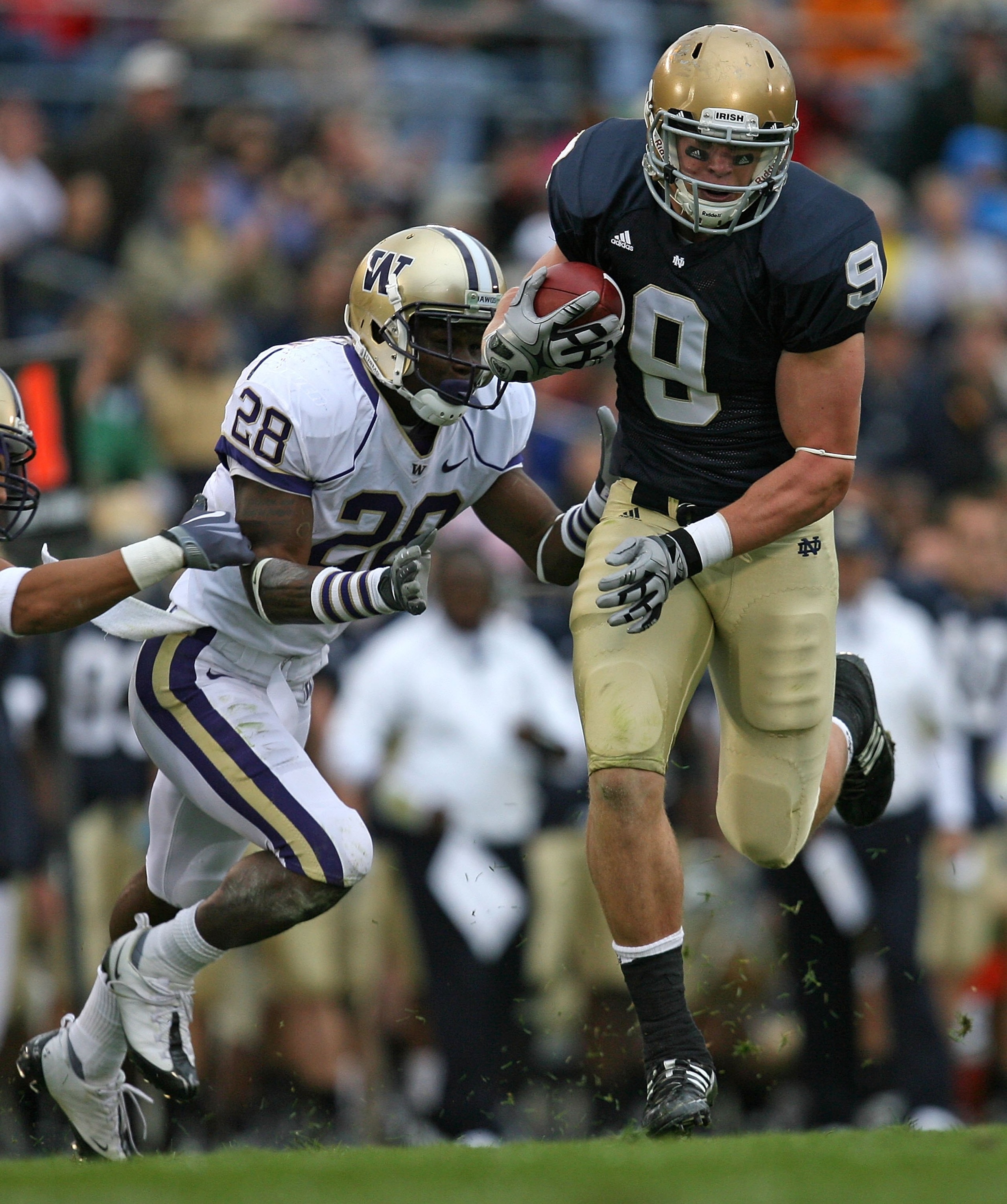 SOUTH BEND, IN - OCTOBER 03: Kyle Rudolph #9 of the Notre Dame Fighting Irish breaks away from Quinton Rochardson #28 of the Washington Huskies after catching the ball on October 3, 2009 at Notre Dame Stadium in South Bend, Indiana. Notre Dame defeated Wa