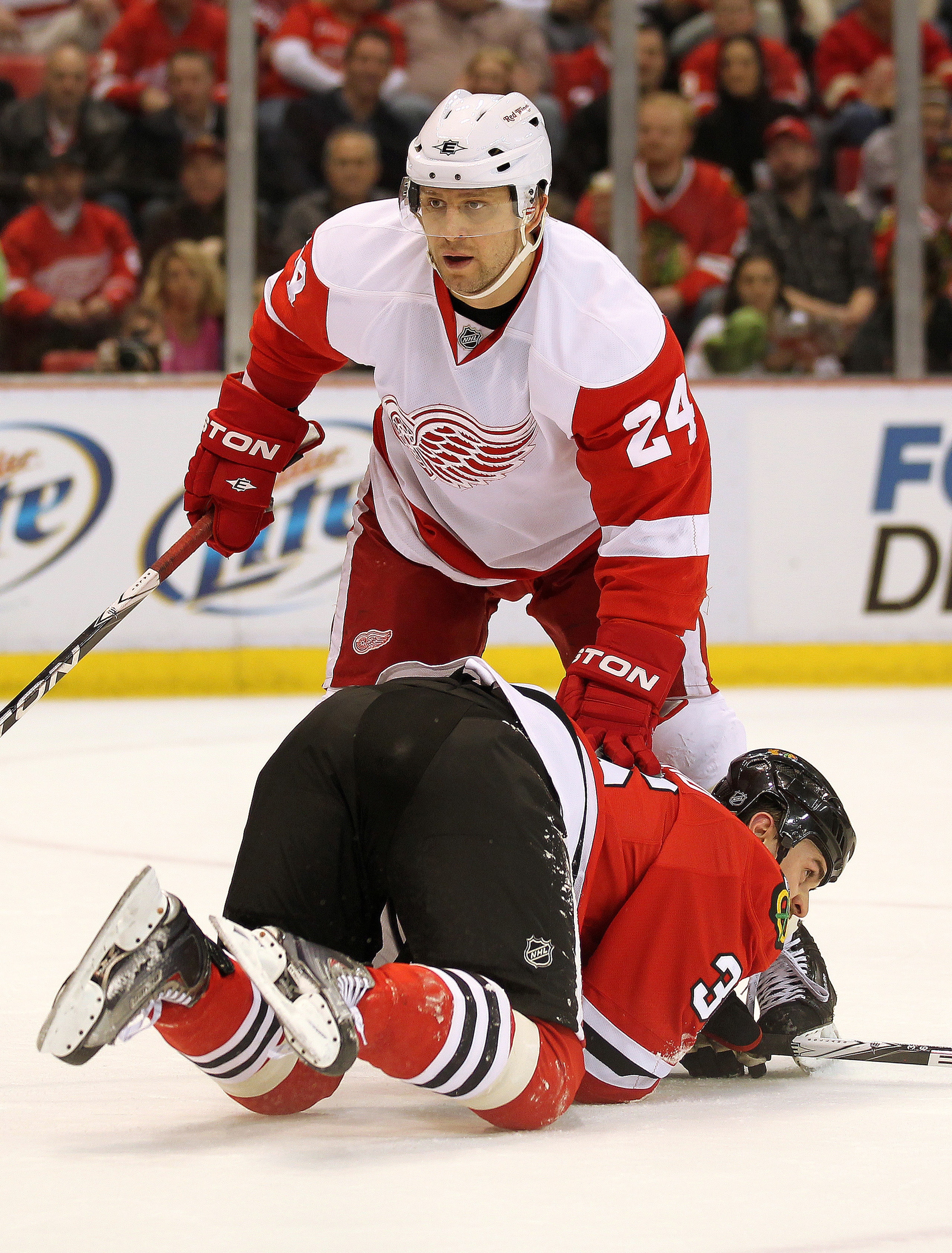 DETROIT, MI - JANUARY 22:  David Bolland #36 of the Chicago Black Hawks is taken down by Ruslan Salei #24 of the Detroit Red Wings in a game on January 22, 2011 at the Joe Louis Arena in Detroit, Michigan. The Hawks defeated the Wings 4-1. (Photo by Claus