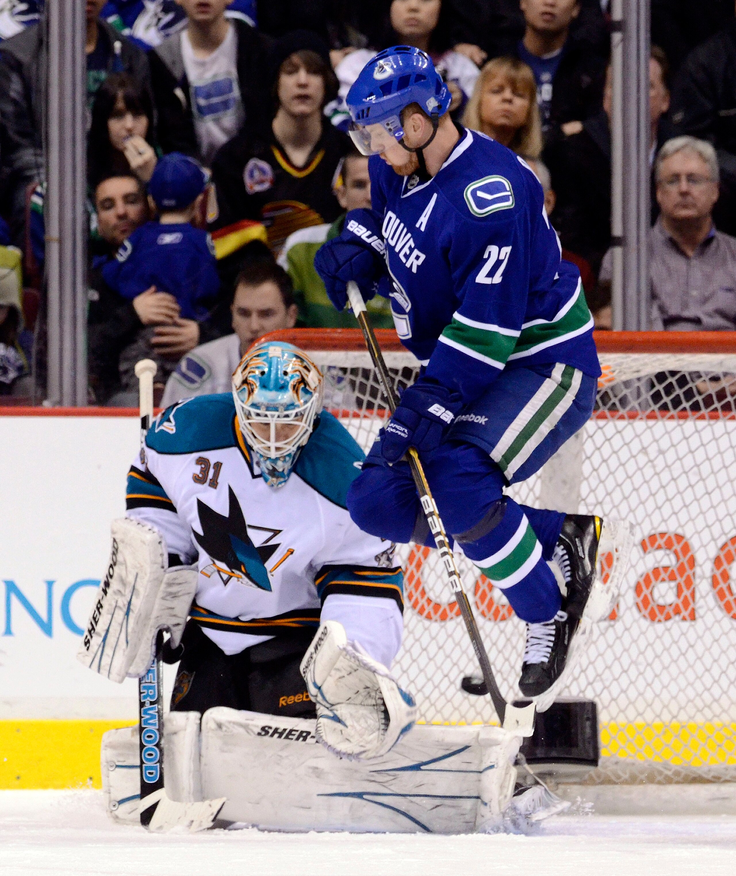 VANCOUVER, CANADA - JANUARY 20: Daniel Sedin #22 of the Vancouver Canucks jumps out of the way as goalie Antti Niemi #31 of the San Jose Sharks makes a save during the first period in NHL action on January 20, 2011 at Rogers Arena in Vancouver, BC, Canada