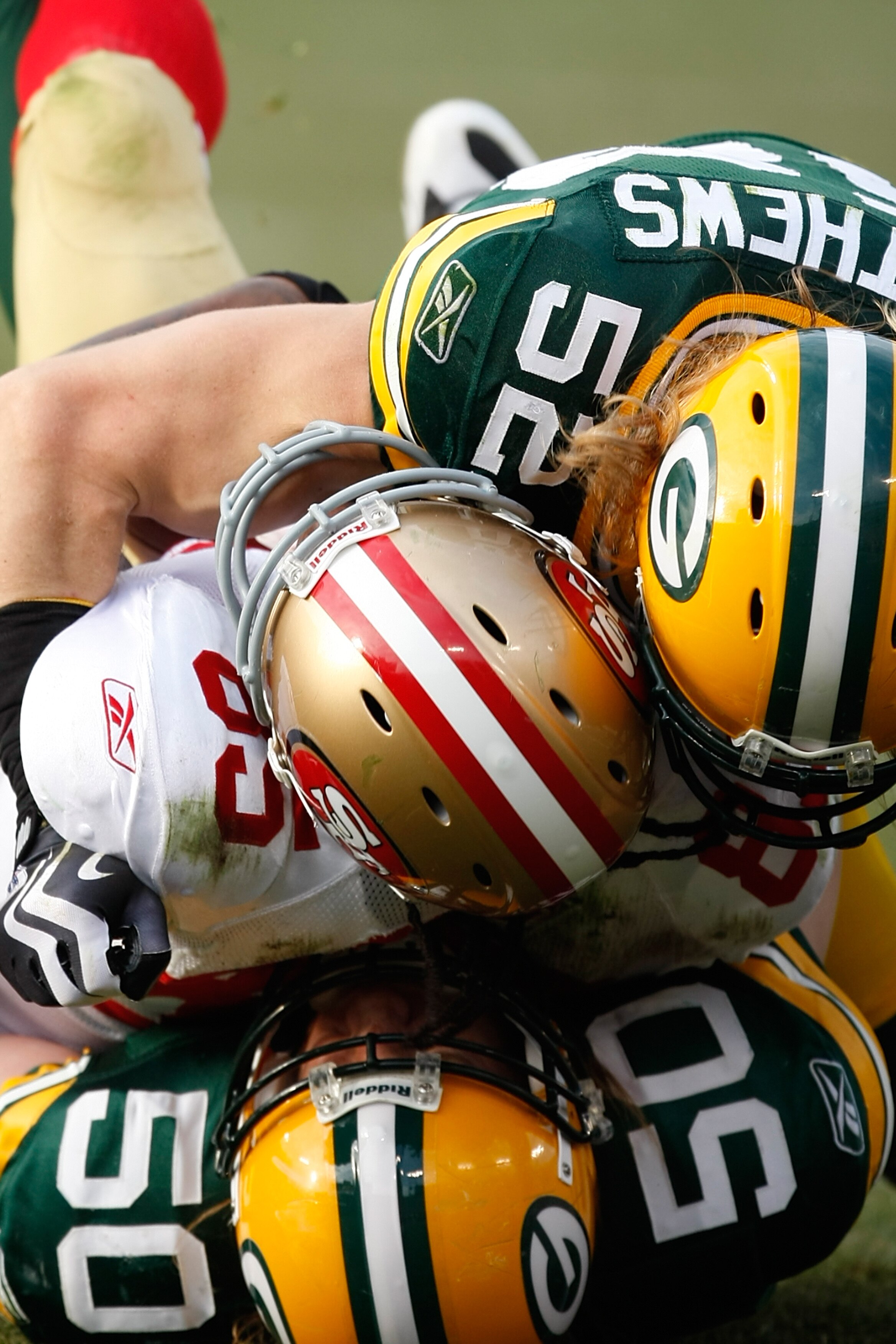 GREEN BAY, WI - NOVEMBER 22: Tight end Vernon Davis #85 of the San Francisco 49ers is tackled by linebackers Clay Matthews #52 and A.J. Hawk #50 of the Green Bay Packers at Lambeau Field on November 22, 2009 in Green Bay, Wisconsin. The Packers defeated t