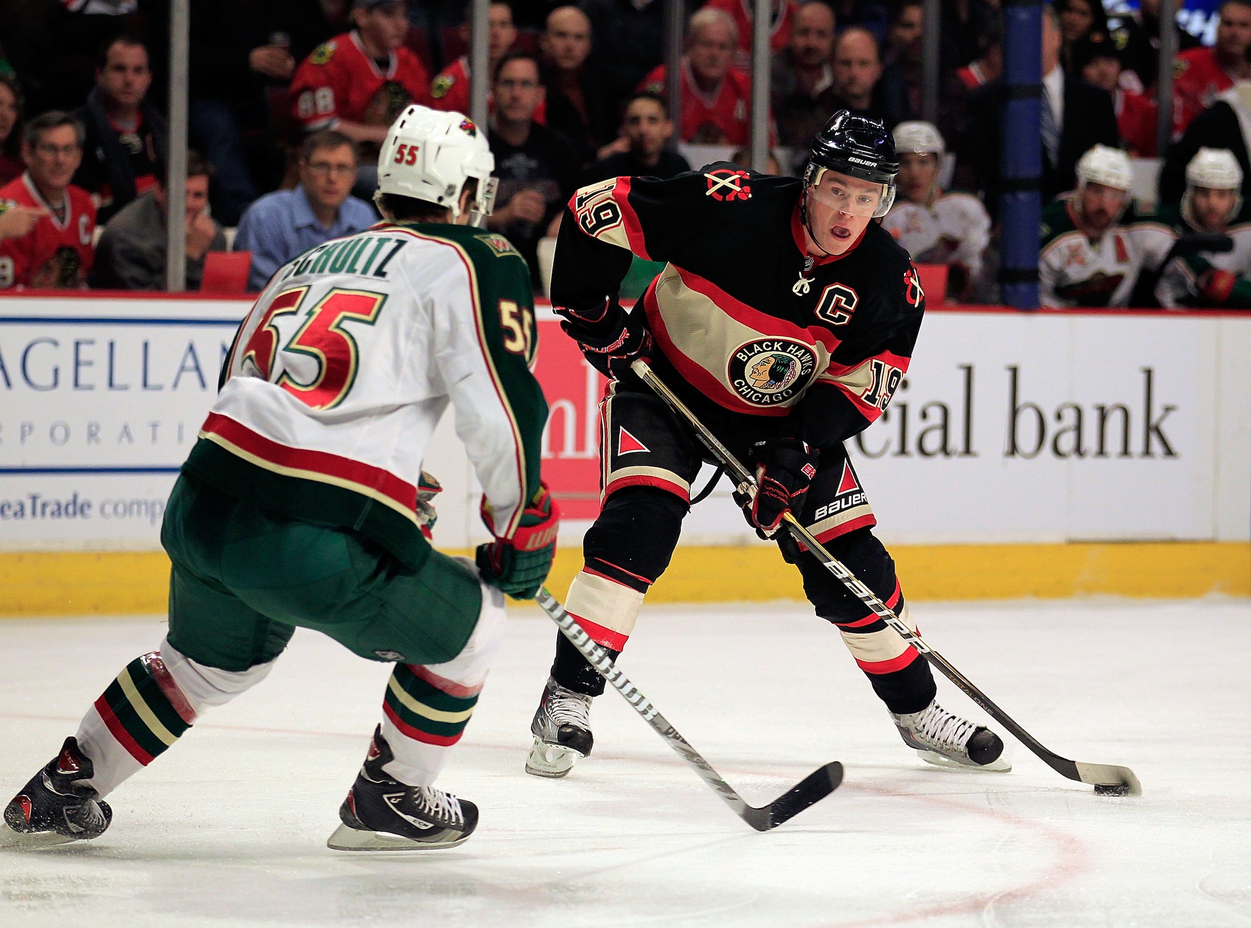 CHICAGO, IL - JANUARY 25: Jonathan Toews #19 of the Chicago Blackhawks controls the puck against Nick Schultz #55 of the Minnesota Wild at the United Center on January 25, 2011 in Chicago, Illinois. The Wild defeated the Blackhawks 4-2. (Photo by Jonathan
