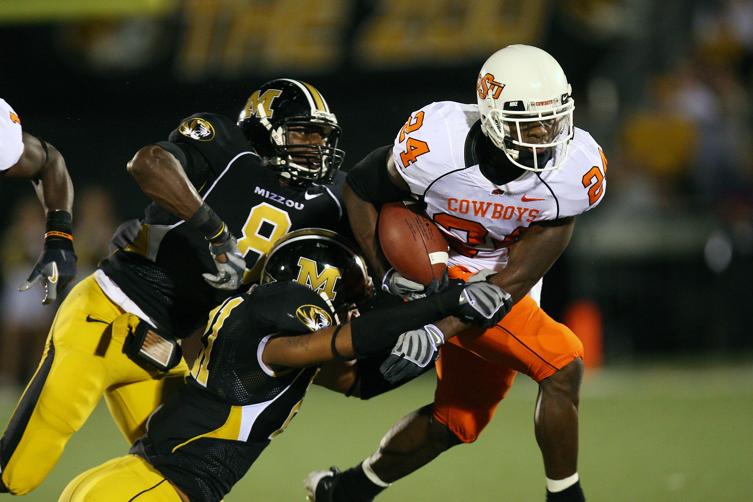 COLUMBIA, MO - OCTOBER 11:  Kendall Hunter #24 of the Oklahoma State Cowboys drags defenders of the Missouri Tigers for yardage on October 11, 2008 at Memorial Stadium in Columbia, Missouri.  (Photo by G. Newman Lowrance/Getty Images)
