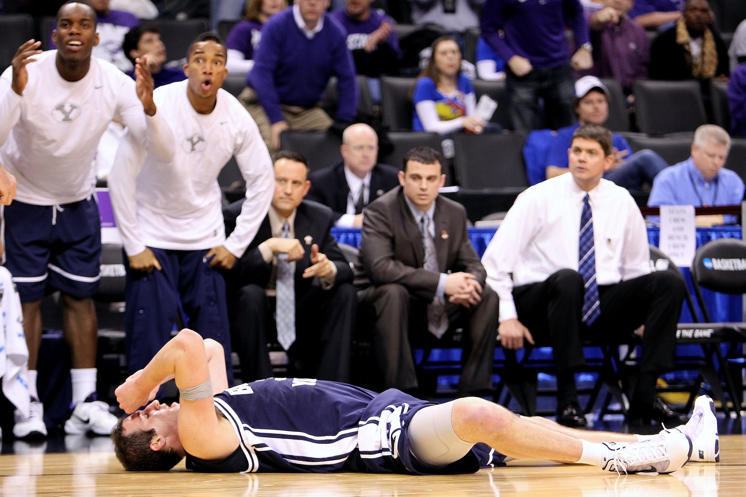 OKLAHOMA CITY - MARCH 20:  Noah Hartsock #34 of the Brigham Young Cougars lies on the court with his hands on his head as his teammates react on the bench against the Kansas State Wildcats during the second round of the 2010 NCAA men's basketball tourname