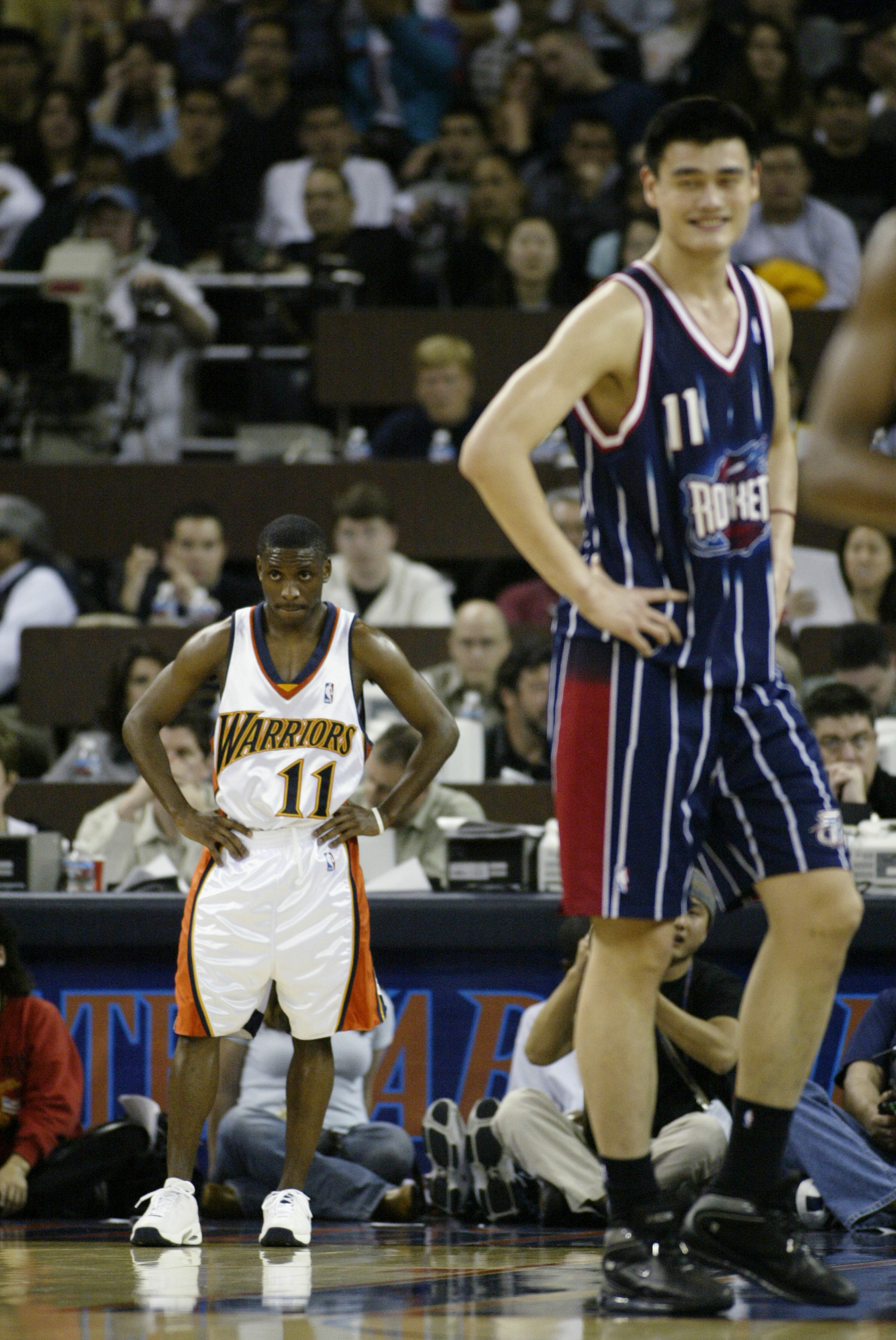 OAKLAND, CA - MARCH 21:  Earl Boykins #11 of the Golden State Warriors and Yao Ming #11 of the Houston Rockets rest during the game at The Arena in Oakland on March 21, 2003 in Oakland, California.  The Rockets won 117-107.  NOTE TO USER: User expressly a