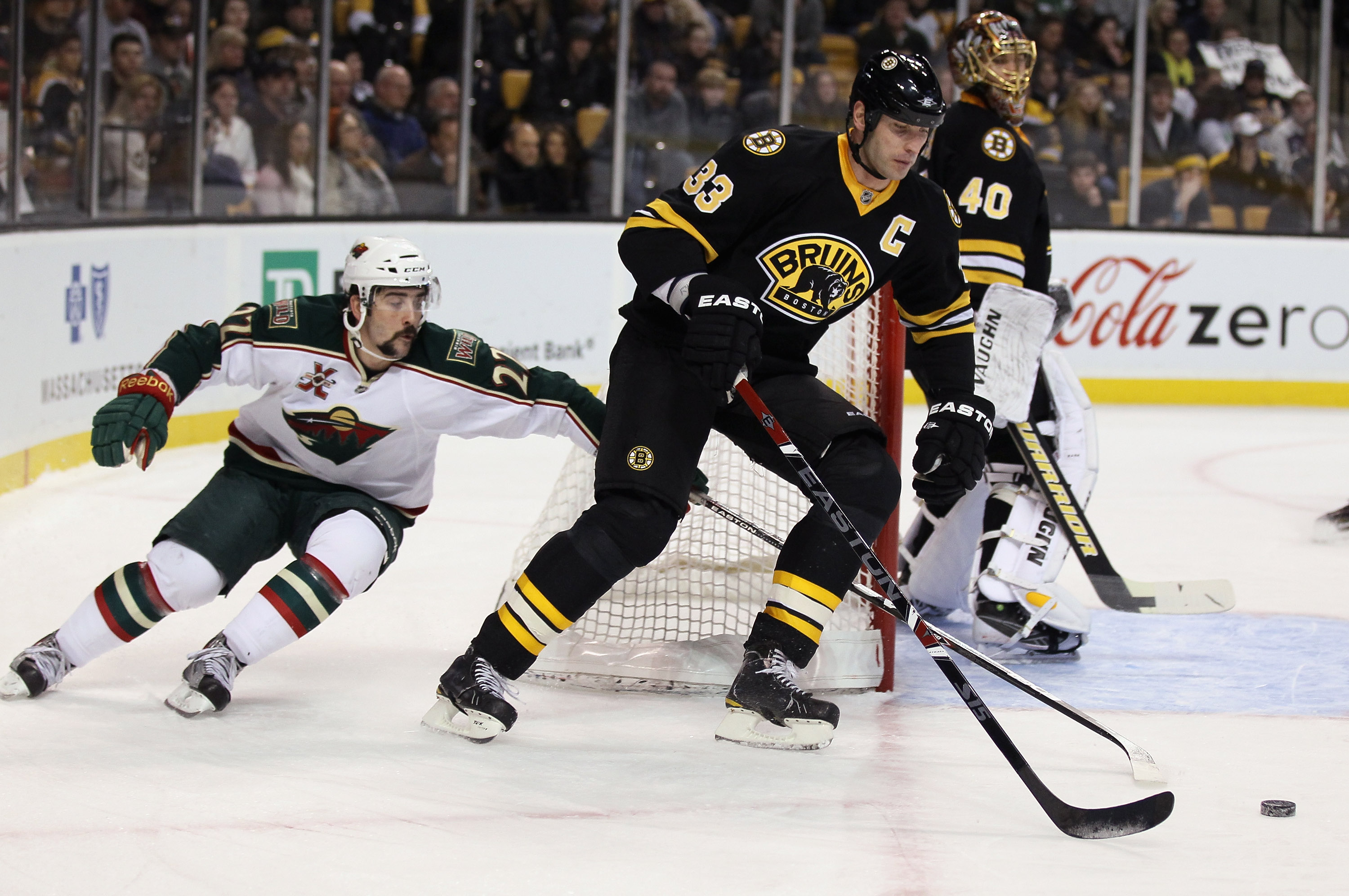 BOSTON, MA - JANUARY 06:  Zdeno Chara #33 of the Boston Bruins takes the puck as Cal Clutterbuck #22 of the Minnesota Wild defends on January 6, 2010 at the TD Garden in Boston, Massachusetts.  (Photo by Elsa/Getty Images)