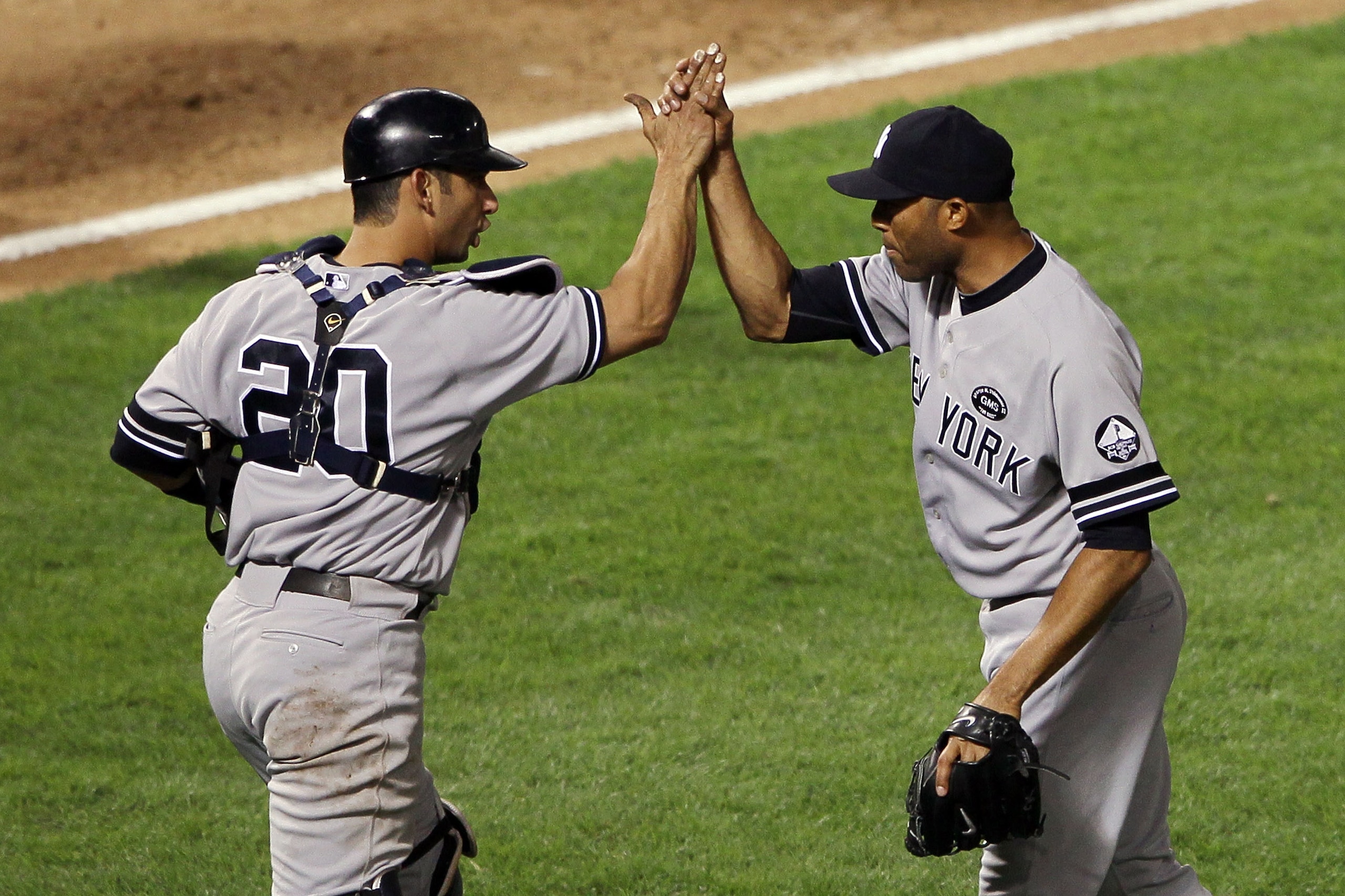 ARLINGTON, TX - OCTOBER 15:  Mariano Rivera #42 and Jorge Posada #20 of the New York Yankees celebrate after defeating the Texas Rangers by a score of 6-5 to win Game One of the ALCS during the 2010 MLB Playoffs at Rangers Ballpark in Arlington on October