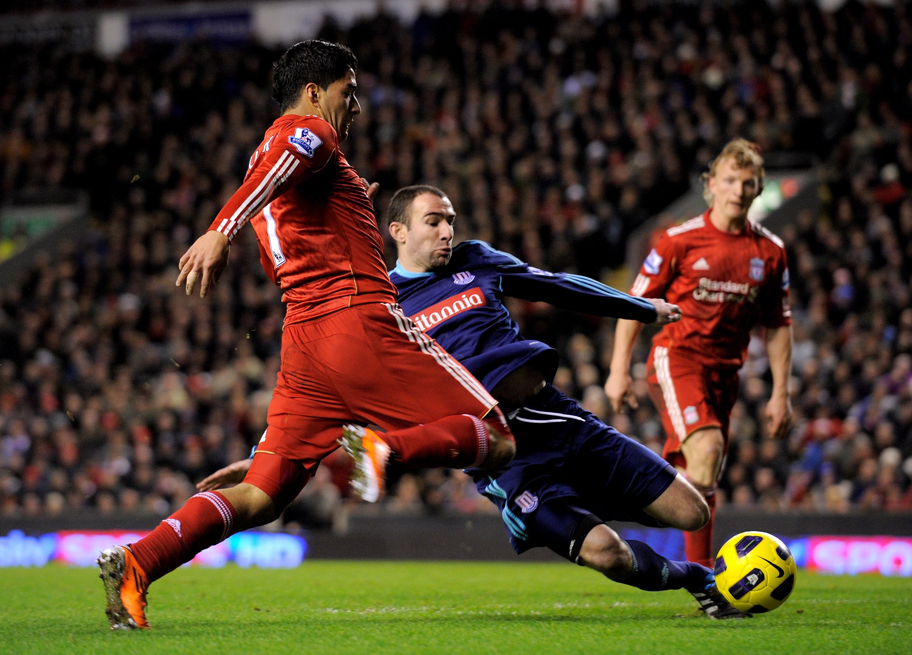 LIVERPOOL, ENGLAND - FEBRUARY 02:  Luis Suarez of Liverpool is challenged by Danny Higginbotham of Stoke City during the Barclays Premier League match between Liverpool and Stoke City at Anfield on February 2, 2011 in Liverpool, England.  (Photo by Michae