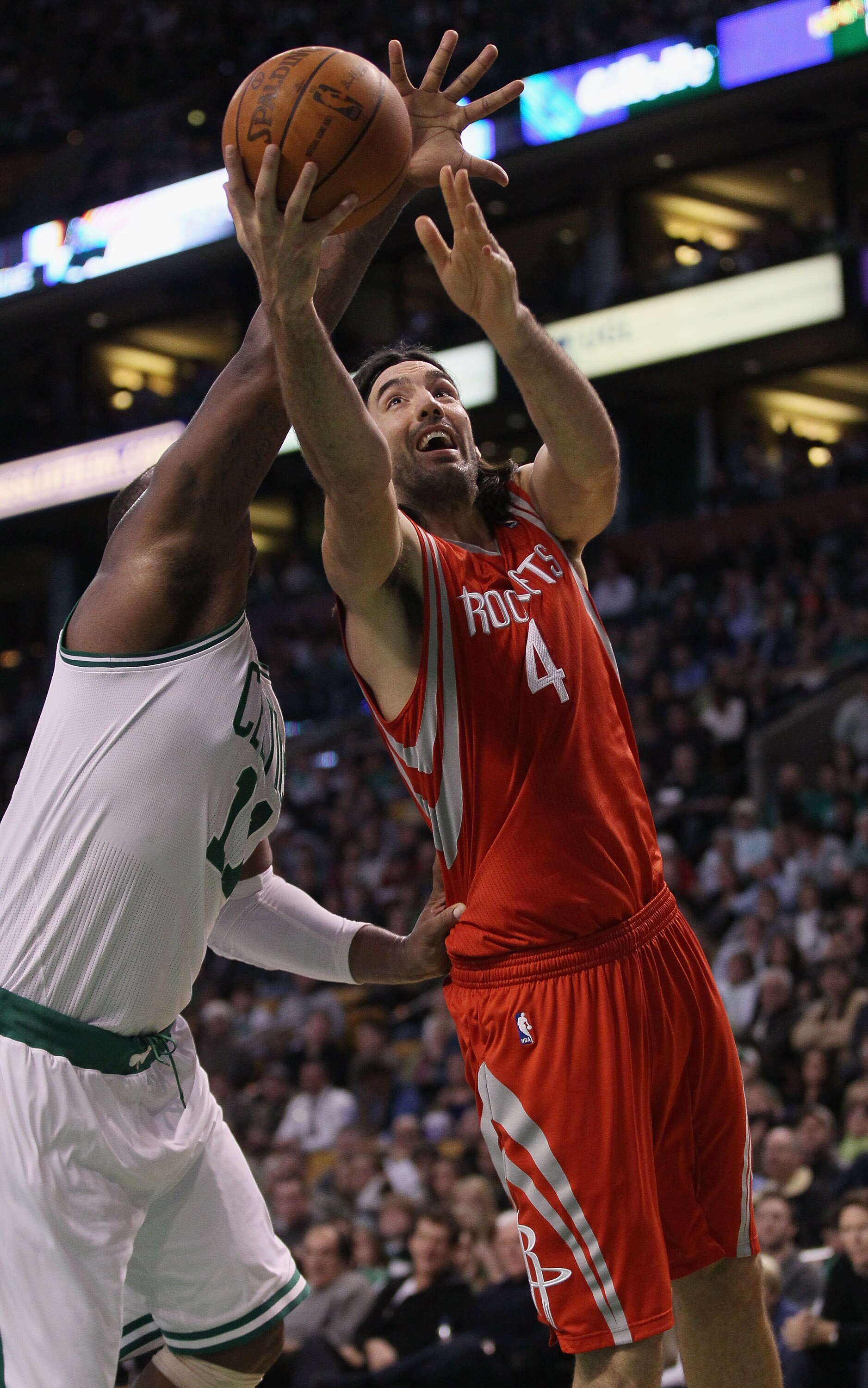 BOSTON, MA - JANUARY 10:  Luis Scola #4 of the Houston Rockets heads for the basket as Glen Davis #11 of the Boston Celtics defends on January 10, 2011 at the TD Garden in Boston, Massachusetts.  The Rockets defeated the Celtics 108-102. NOTE TO USER: Use