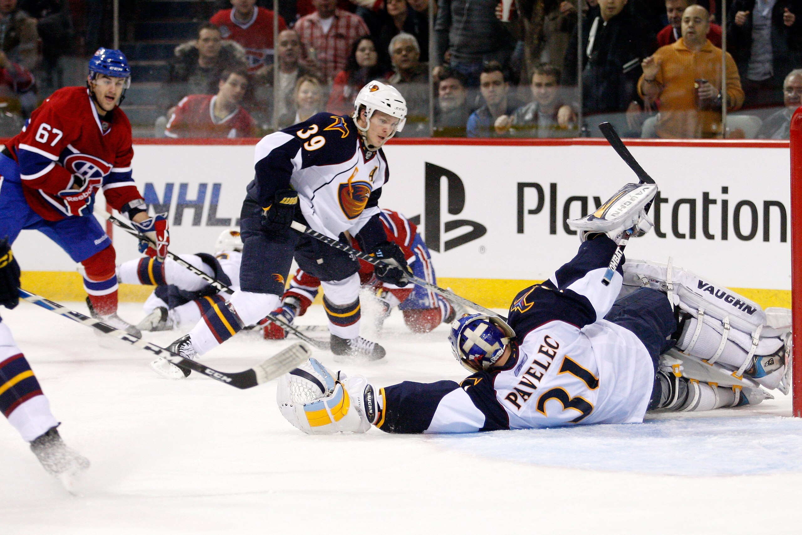 MONTREAL, CANADA - JANUARY 2:  Ondrej Pavelec #31 of the Atlanta Thrashers stretches out to stop the losse puck in front of teammate Tobias Enstrom #39 during the NHL game against the Montreal Canadiens at the Bell Centre on January 2, 2011 in Montreal, Q