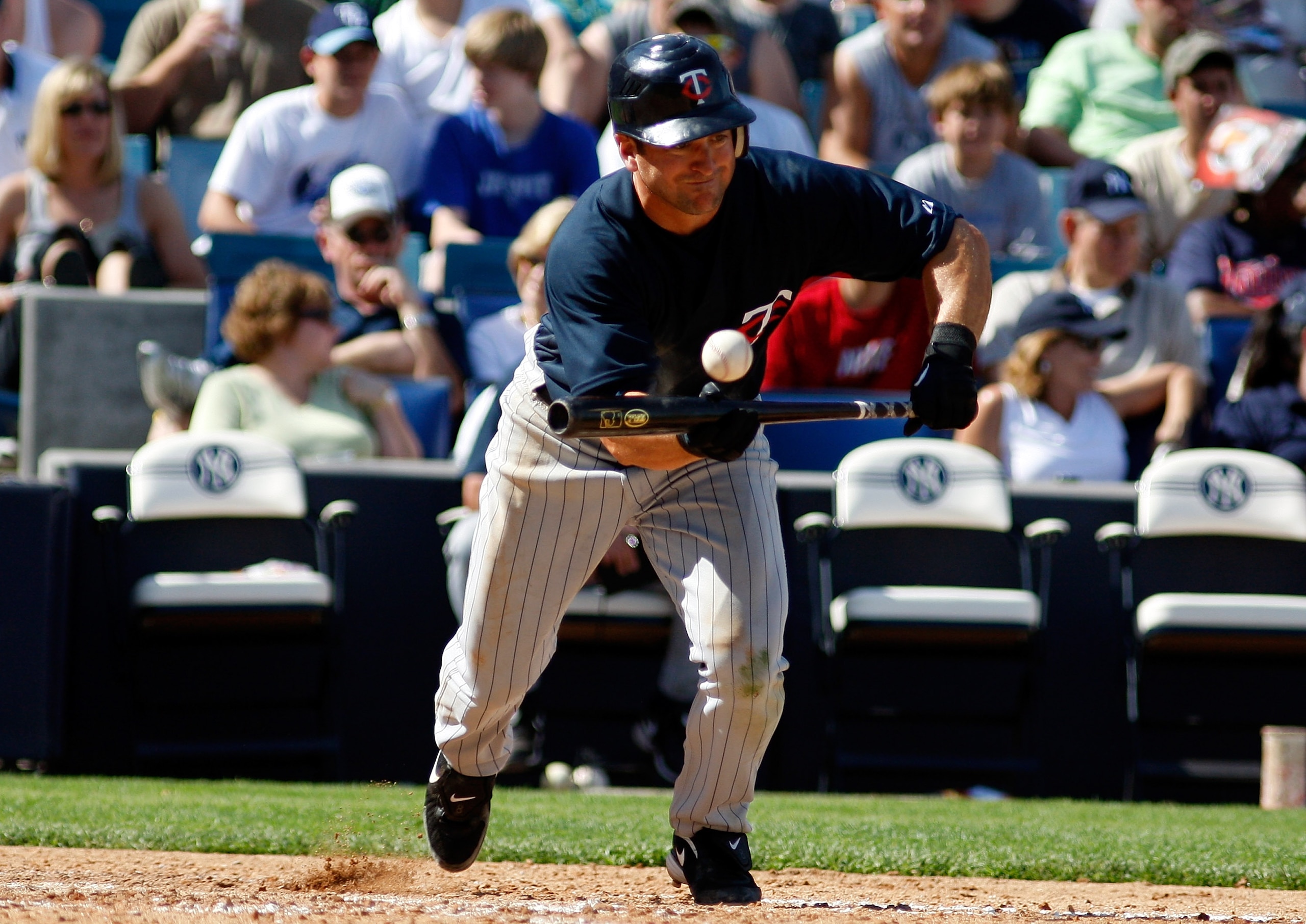 TAMPA, FL - FEBRUARY 28:  Shortstop Nick Punto #8 of the Minnesota Twins bunts against the New York Yankees during a Grapefruit League Spring Training Game at George M. Steinbrenner Field on February 28, 2009 in Tampa, Florida.  (Photo by J. Meric/Getty I