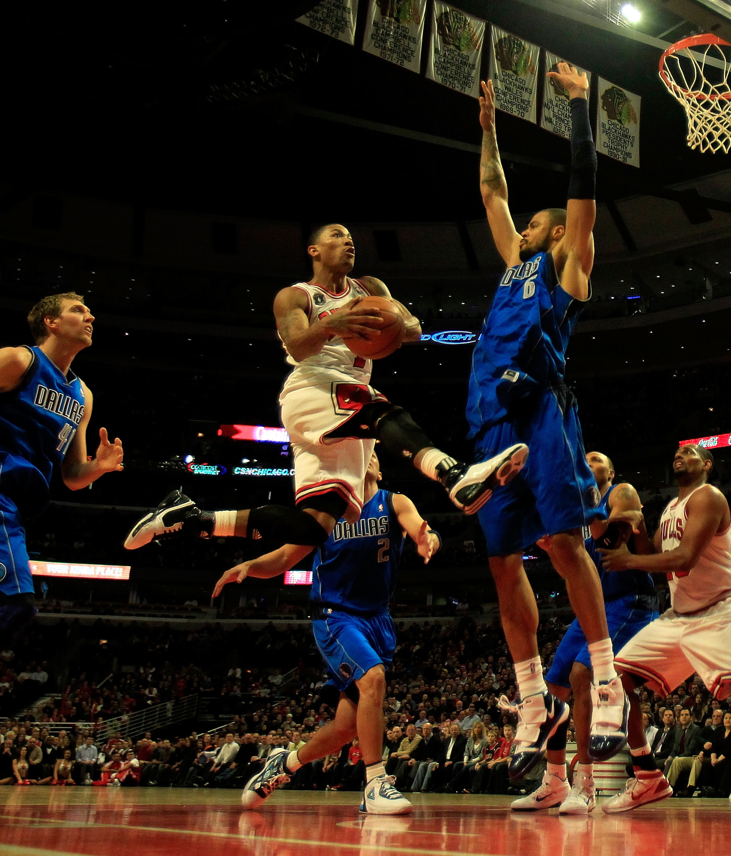 CHICAGO, IL - JANUARY 20: Derrick Rose #1 of the Chicago Bulls goes up for a shot between Dirk Nowitzki #41 (L) and Tyson Chandler #6 of the Dallas Mavericks at the United Center on January 20, 2011 in Chicago, Illinois. The Bulls defeated the Mavericks 8