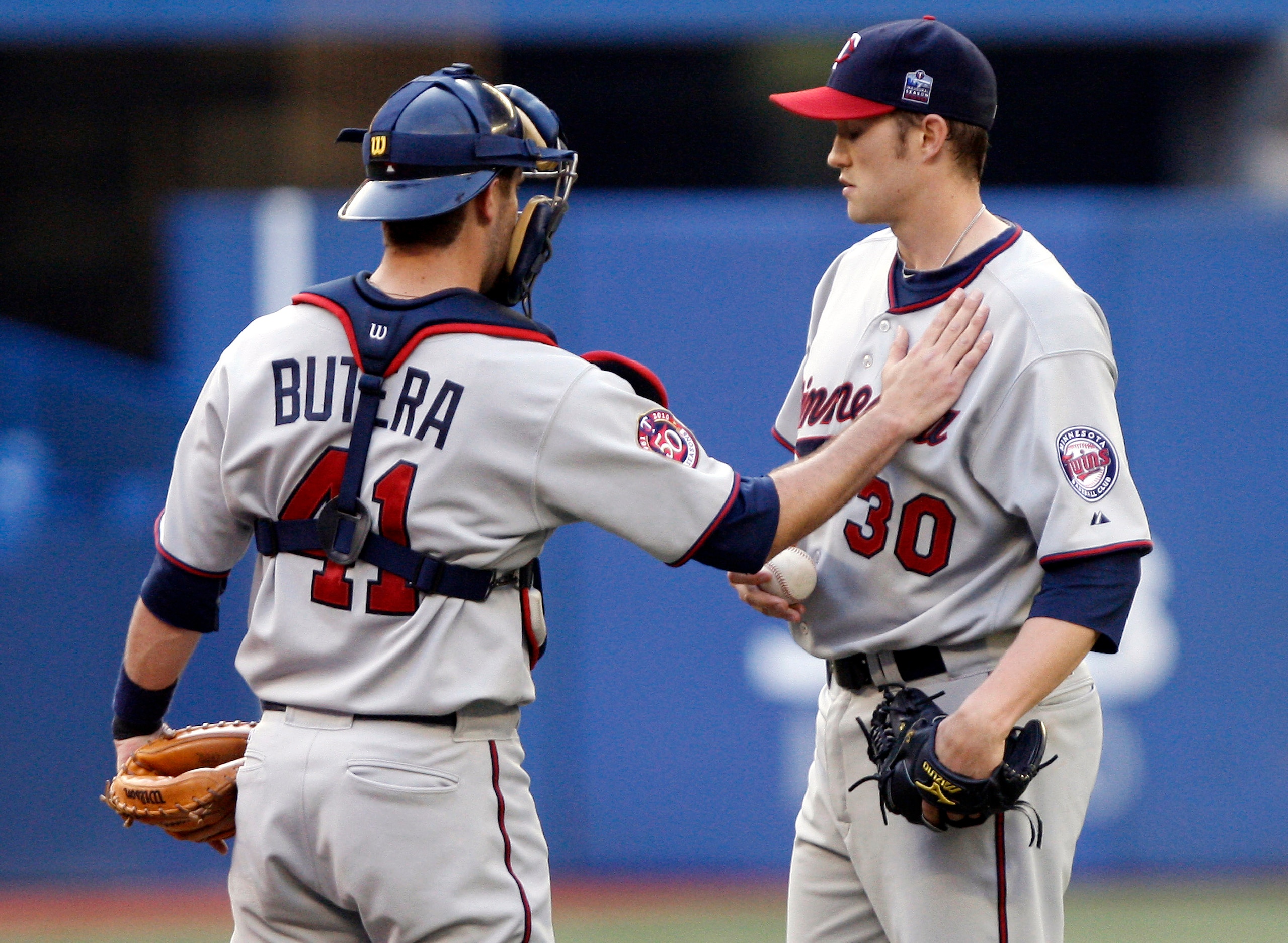 TORONTO - JULY 8: Drew Butera #41 comforts Scott Baker #30 of the Minnesota Twins after an Adam Lind home run during a MLB game against the Toronto Blue Jays at The Rogers Centre July 8, 2010 in Toronto, Ontario, Canada. (Photo by Abelimages/Getty Images)