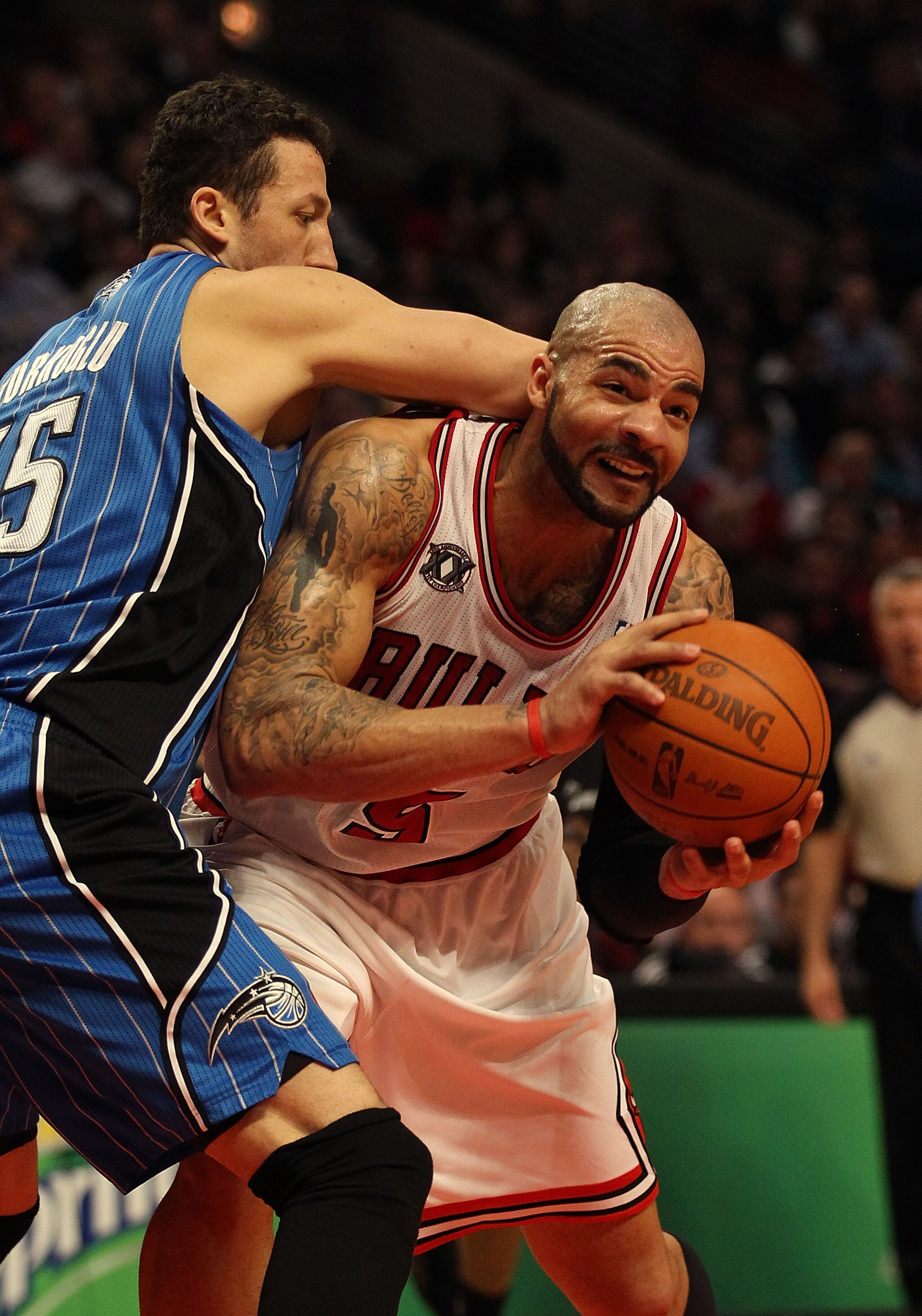 CHICAGO, IL - JANUARY 28: Carlos Boozer #5 of the Chicago Bulls looks to pass under pressure from Hedo Turkoglu #15 of the Orlando Magic at the United Center on January 28, 2011 in Chicago, Illinois. The Bulls defeated the Magic 99-90. NOTE TO USER: User