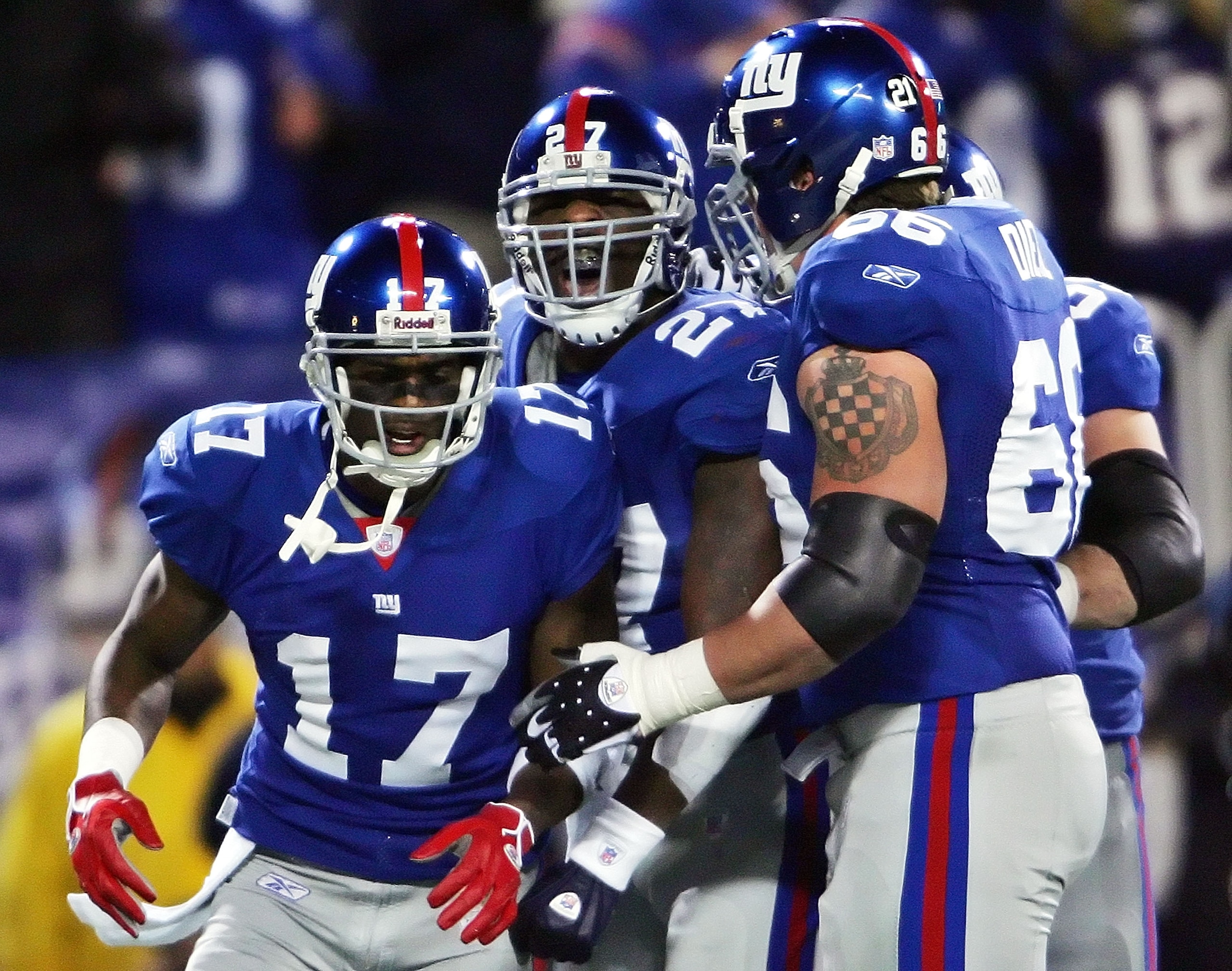 EAST RUTHERFORD, NJ - DECEMBER 29:  Brandon Jacobs #27 of the New York Giants celebrates with teammates Plaxico Burress #17 and  David Diehl #66 after scoring a touchdown on the first drive of the game against the New England Patriots on December 29, 2007
