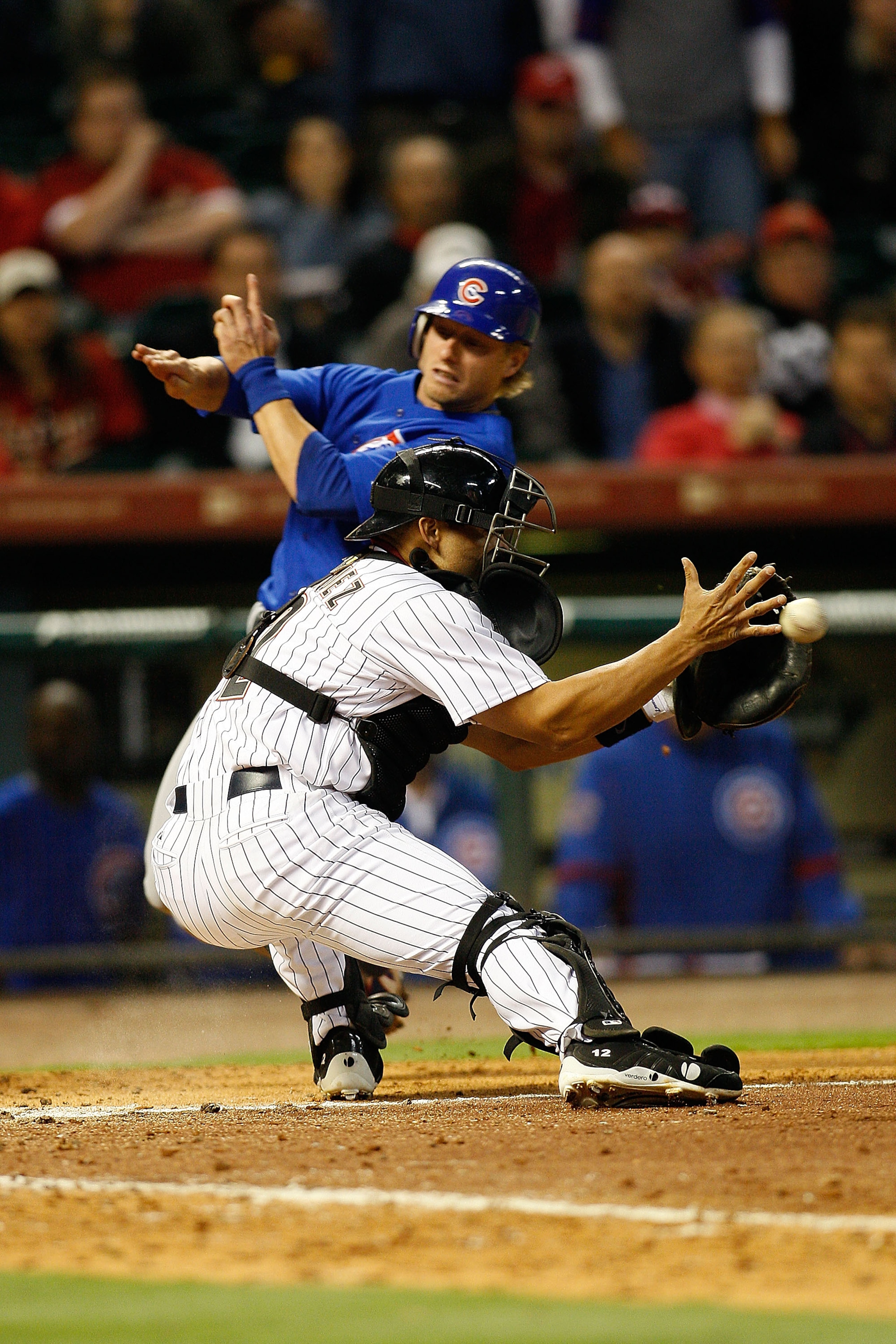 HOUSTON - APRIL 06:  Mike Fontenot #17 of the Chicago Cubs gets around Pudge Rodriguez #12 of the Houston Astros to score a run in the ninth inning on Opening Day on April 6, 2009 at Minute Maid Park in Houston, Texas.  (Photo by Chris Graythen/Getty Imag