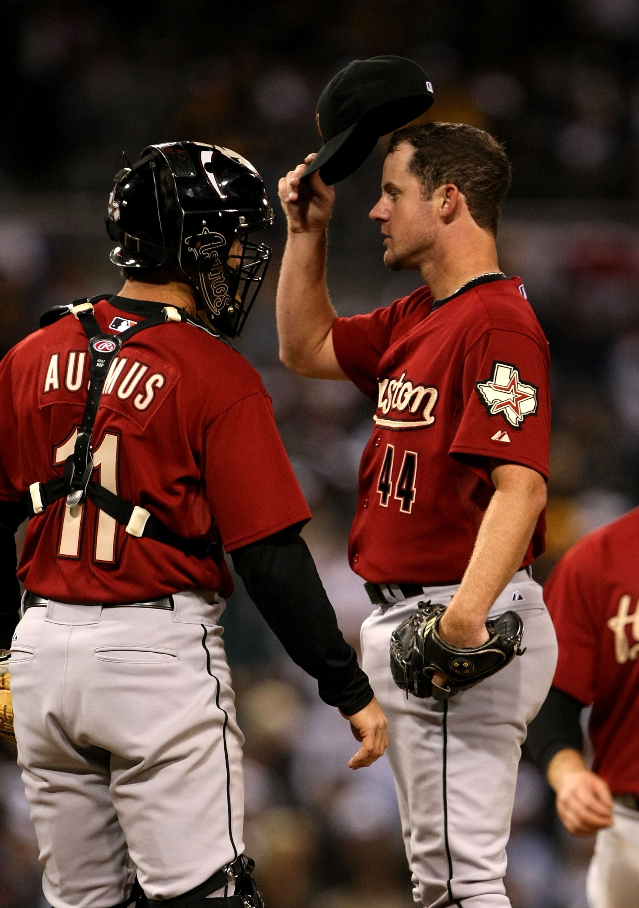 SAN DIEGO - MARCH 31:  Pitcher Roy Oswalt #44 of the Houston Astros  adjusts his cap as he meets on the mound with catcher Brad Ausmus #11 in the game against the San Diego Padres on March 31, 2008 at Petco Park in San Diego, California.   (Photo by Steph