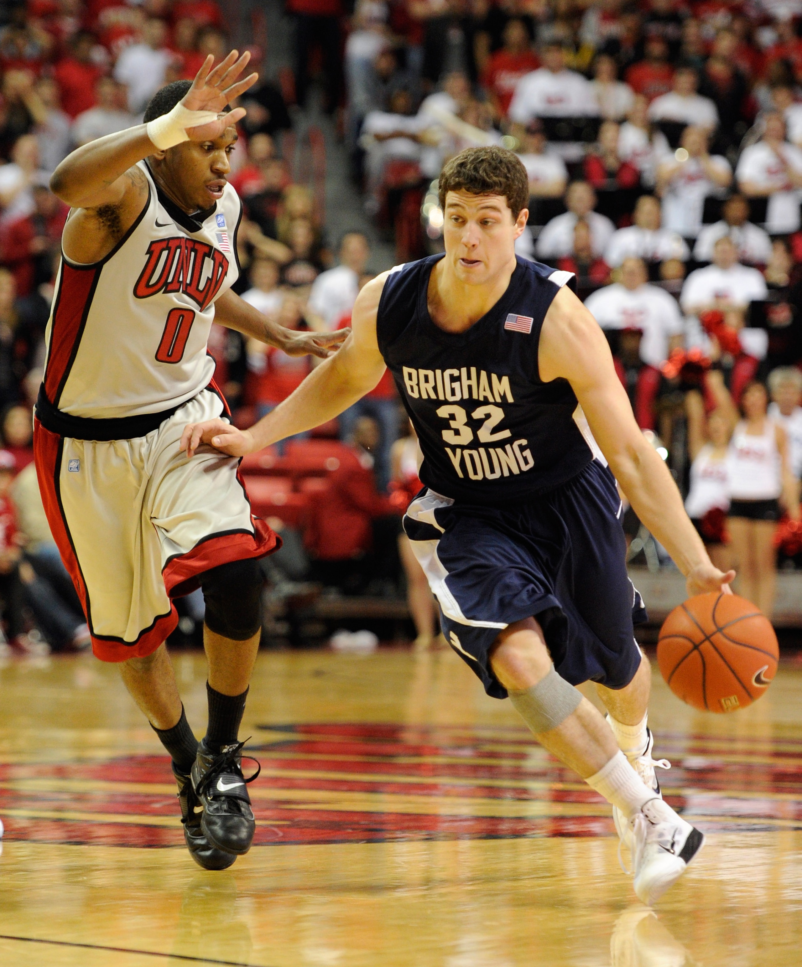 LAS VEGAS, NV - JANUARY 05:   Jimmer Fredette #32 of the Brigham Young University Cougars drives against Oscar Bellfield #0 of the UNLV Rebels during their game at the Thomas & Mack Center January 5, 2011 in Las Vegas, Nevada. BYU won 89-77.  (Photo by Et