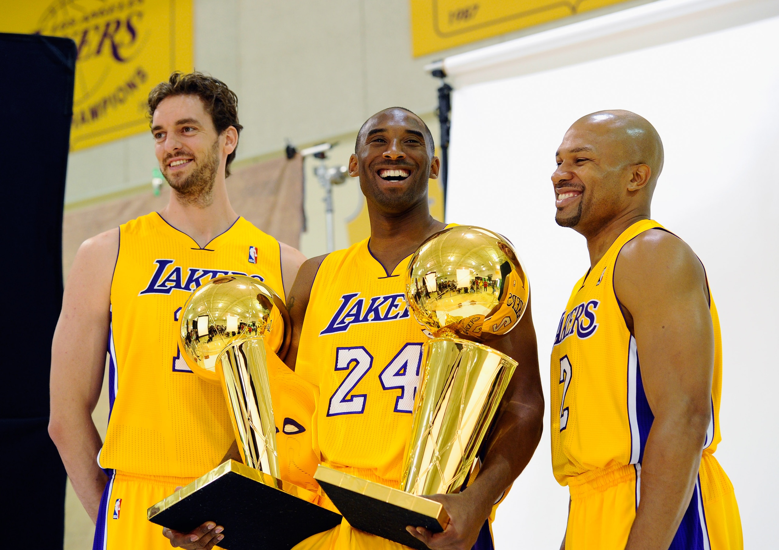 EL SEGUNDO, CA - SEPTEMBER 25: Kobe Bryant #24 of the Los Angeles Lakers smiles as he holds two NBA Finals Larry O'Brien Championship Trophy's as he poses for a photograph with teammates Pau Gasol #16 and Derek Fisher #2 during Media Day at the Toyota C EL SEGUNDO, CA - SEPTEMBER 25: Kobe Bryant #24 of the Los Angeles Lakers smiles as he holds two NBA Finals Larry O'Brien Championship Trophy's as he poses for a photograph with teammates Pau Gasol #16 and Derek Fisher #2 during Media Day at the Toyota C