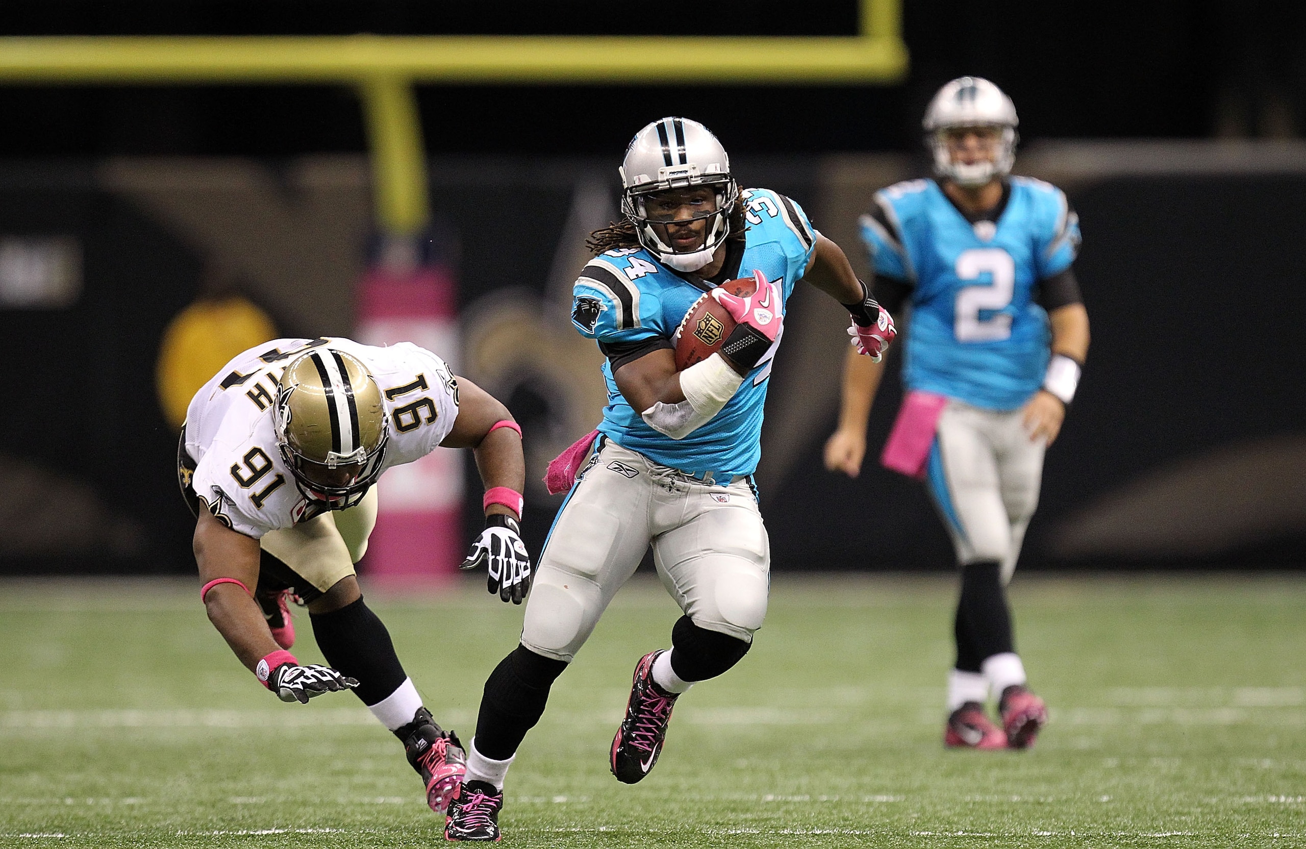 NEW ORLEANS - OCTOBER 03:  Running back DeAngelo Williams #34 of the Carolina Panthers runs for a touchdown past Will Smith #91 of the New Orleans Saints at the Louisiana Superdome on October 3, 2010 in New Orleans, Louisiana.  (Photo by Ronald Martinez/G