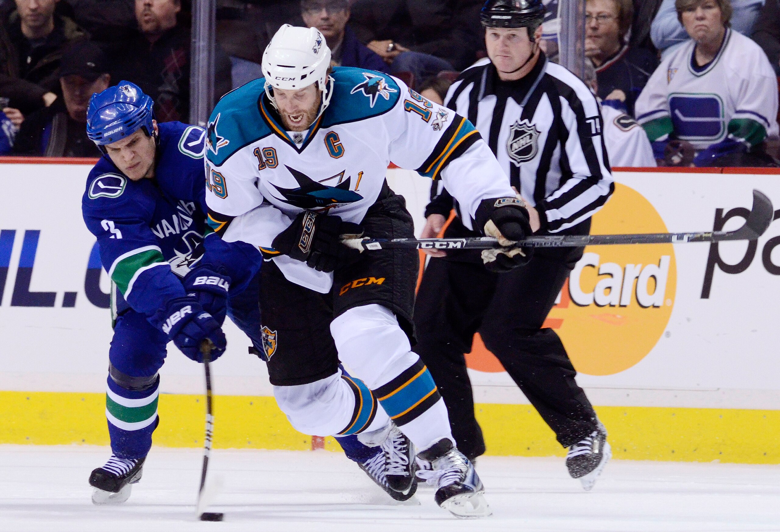 VANCOUVER, CANADA - JANUARY 20: Kevin Bieksa #3 of the Vancouver Canucks gets his stick on the puck while trying to defend against Joe Thornton #19 of the San Jose Sharks during the second period in NHL action on January 20, 2011 at Rogers Arena in Vancou