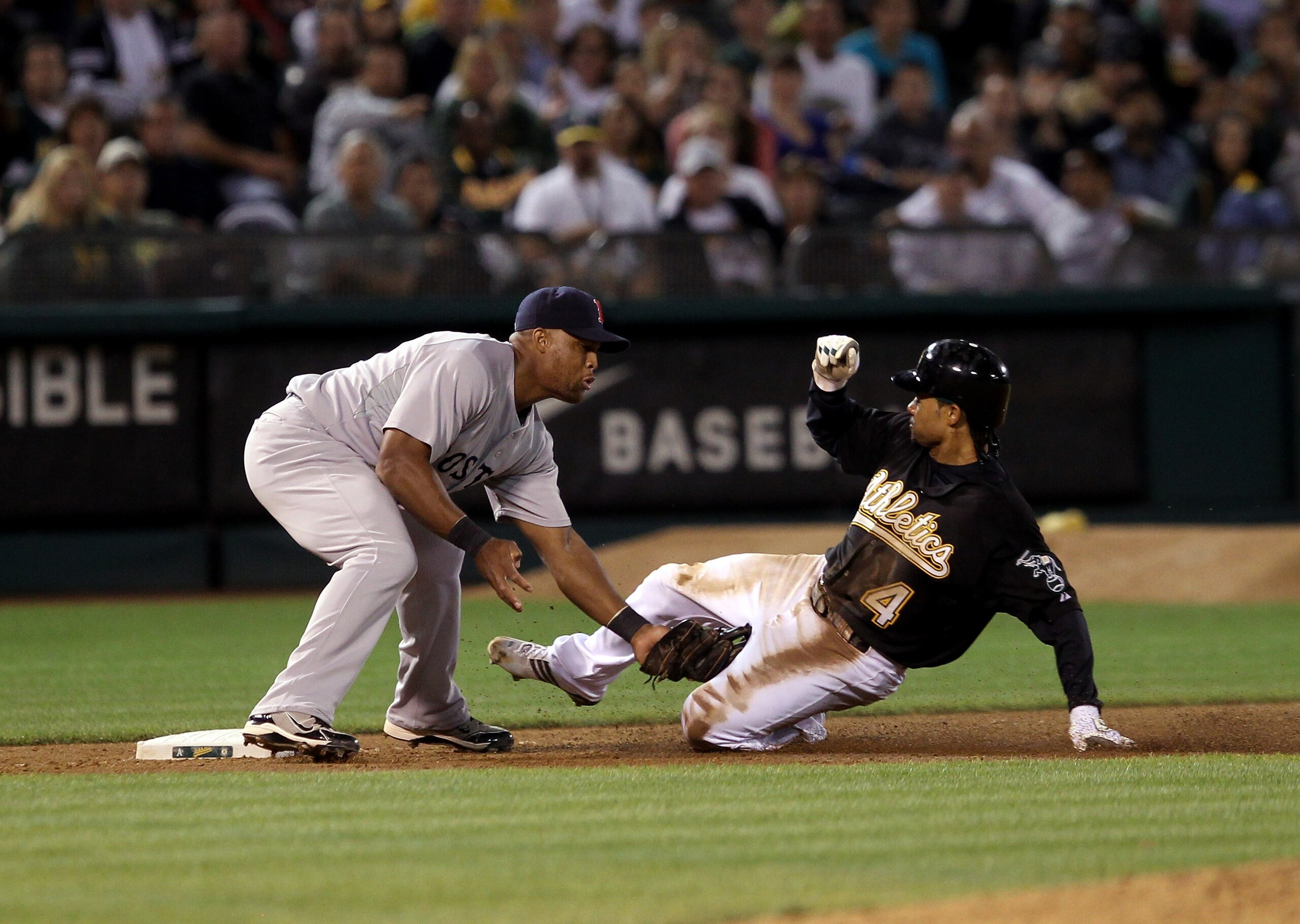 OAKLAND, CA - SEPTEMBER 10:  Coco Crisp #4 of the Oakland Athletics is tagged out by Adrian Beltre #29 of the Boston Red Sox after Crisp tried to reach third base after tagging up on a fly out to center field at the Oakland-Alameda County Coliseum on Sept