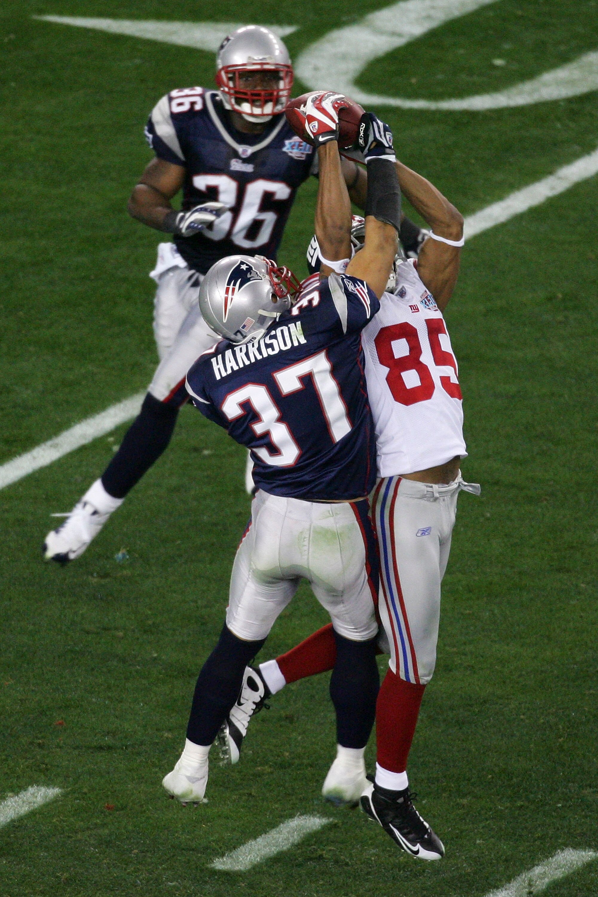 GLENDALE, AZ - FEBRUARY 03:  David Tyree #85 of the New York Giants catches a 32-yard pass from Eli Manning #10 as Rodney Harrison #37 of the New England Patriots attempts to knock it out in the fourth quarter of Super Bowl XLII on February 3, 2008 at the