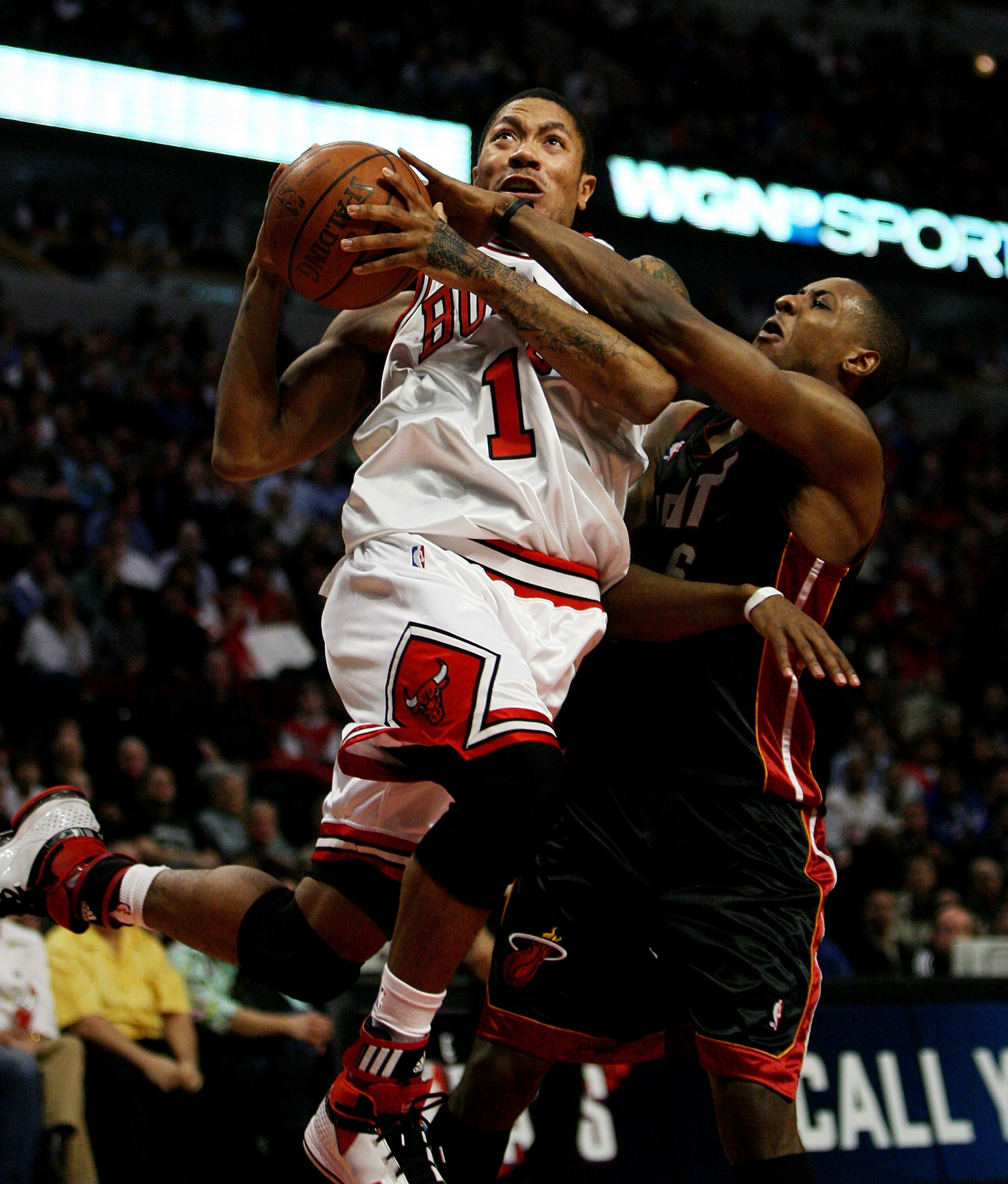 CHICAGO - FEBRUARY 12:  Derrick Rose #1 of the Chicago Bulls is fouled going up for a shot by Mario Chalmers #6 of the Miami Heat on February 12, 2009 at the United Center in Chicago, Illinois. The Heat defeated the Bulls 95-93. NOTE TO USER: User express