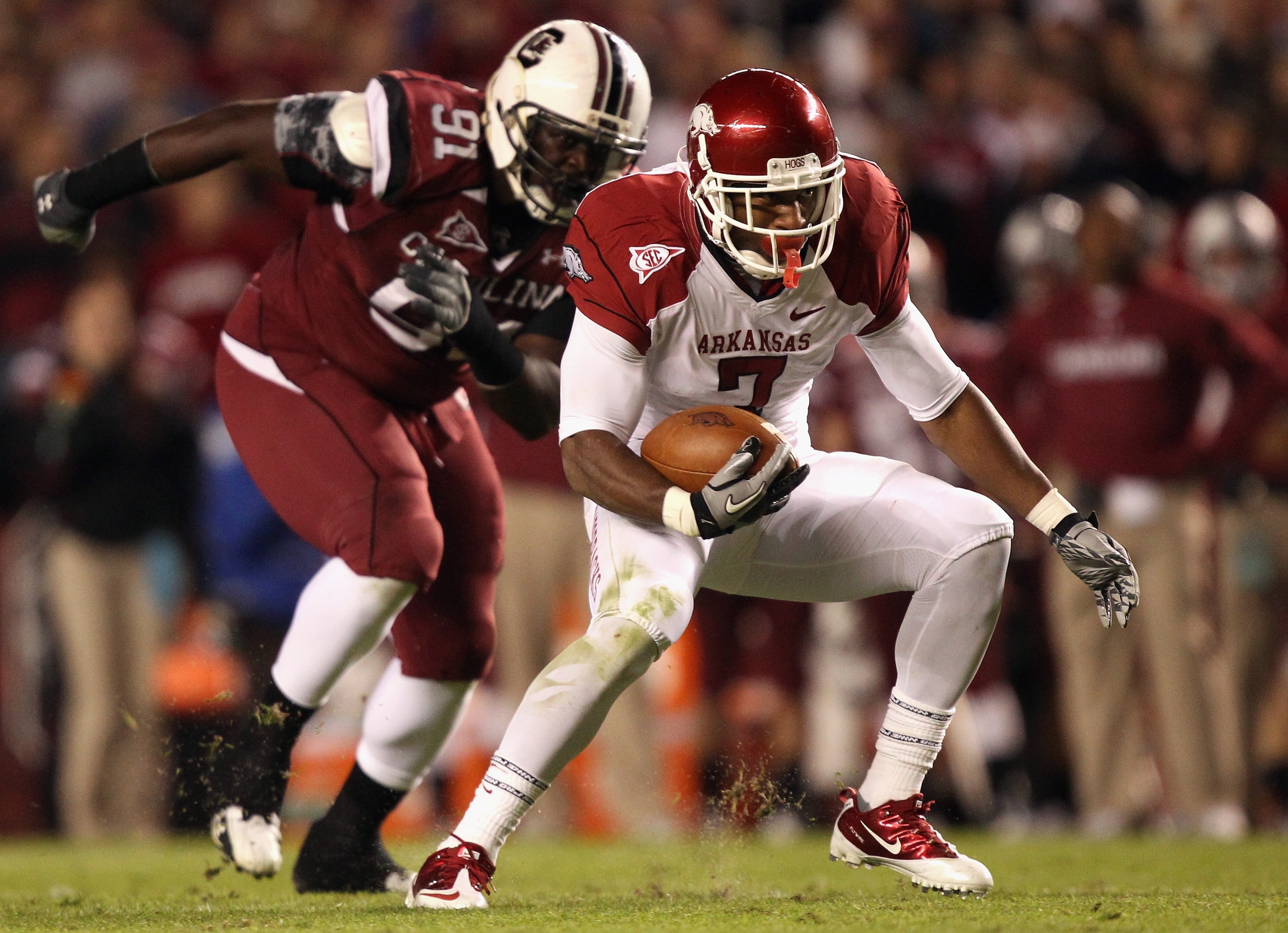 COLUMBIA, SC - NOVEMBER 06:  Knile Davis #7 of the Arkansas Razorbacks runs with the ball as Ladi Ajiboye #91 of the South Carolina Gamecocks runs after him during their game at Williams-Brice Stadium on November 6, 2010 in Columbia, South Carolina.  (Pho