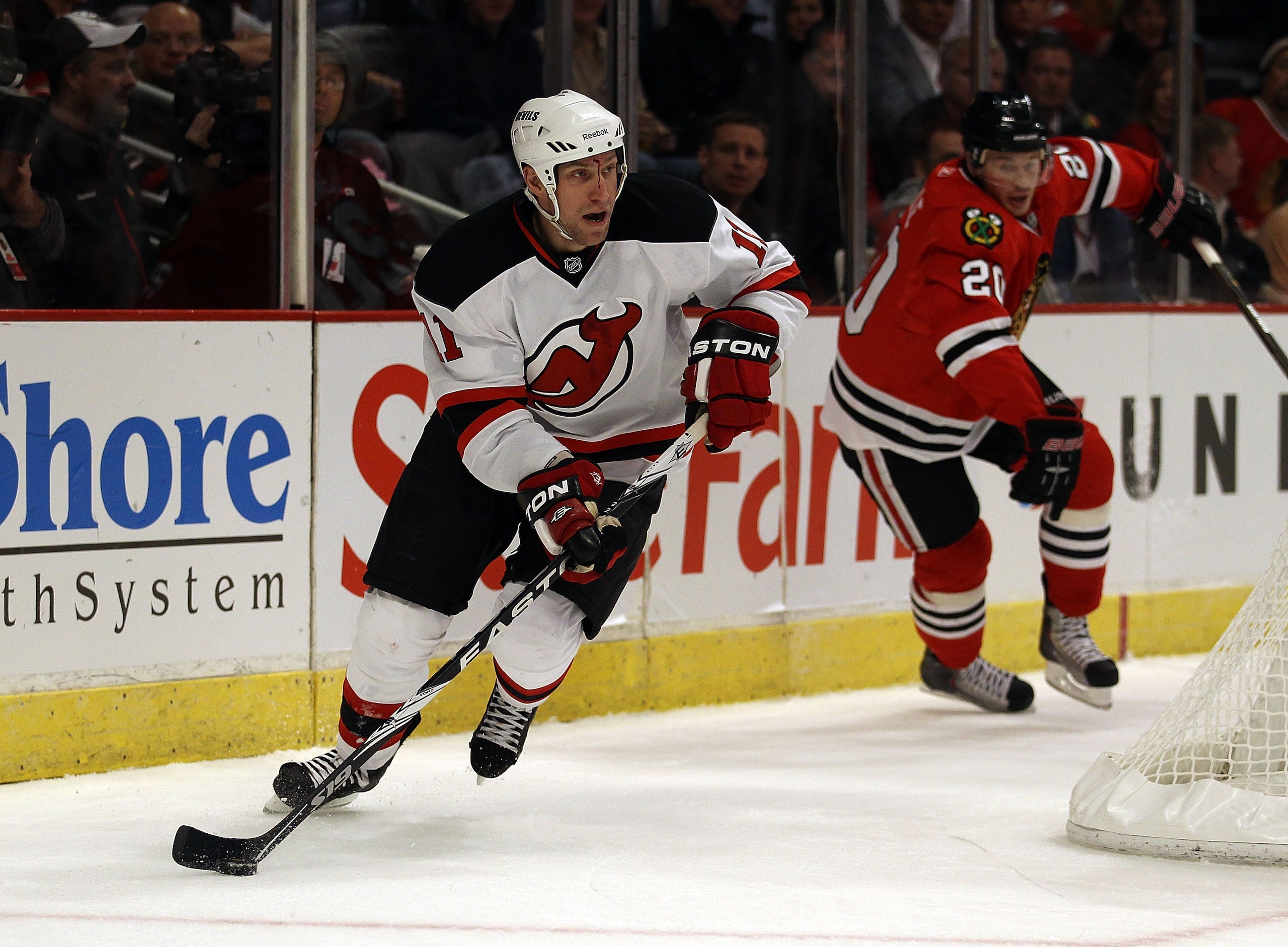 CHICAGO - NOVEMBER 03: Adam Mair #11 of the New Jersey Devils looks to pass after moving past Jack Skille #20 of the Chicago Blackhawks at the United Center on November 3, 2010 in Chicago, Illinois. The Devils defeated the Blackhawks 5-3.  (Photo by Jonat