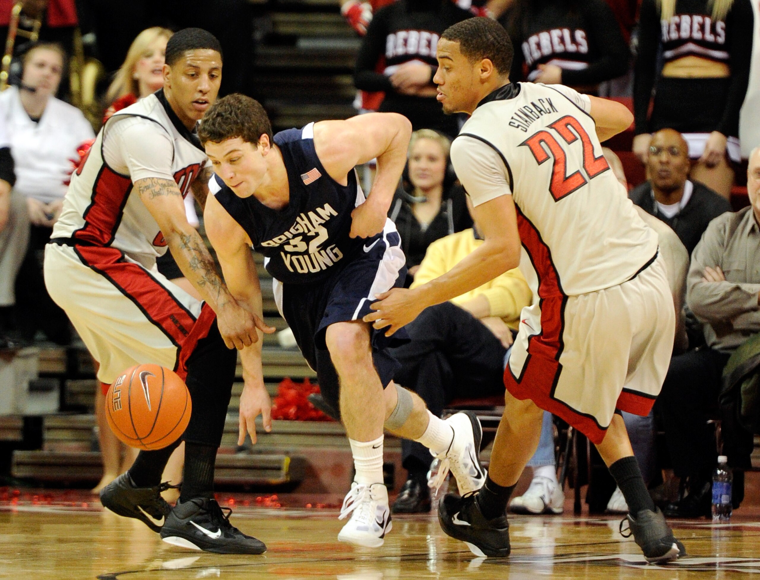 LAS VEGAS, NV - JANUARY 05:  Jimmer Fredette #32 of the Brigham Young University Cougars breaks a trap by Tre'Von Willis #33 and Chace Stanback #22 of the UNLV Rebels during their game at the Thomas & Mack Center January 5, 2011 in Las Vegas, Nevada. BYU