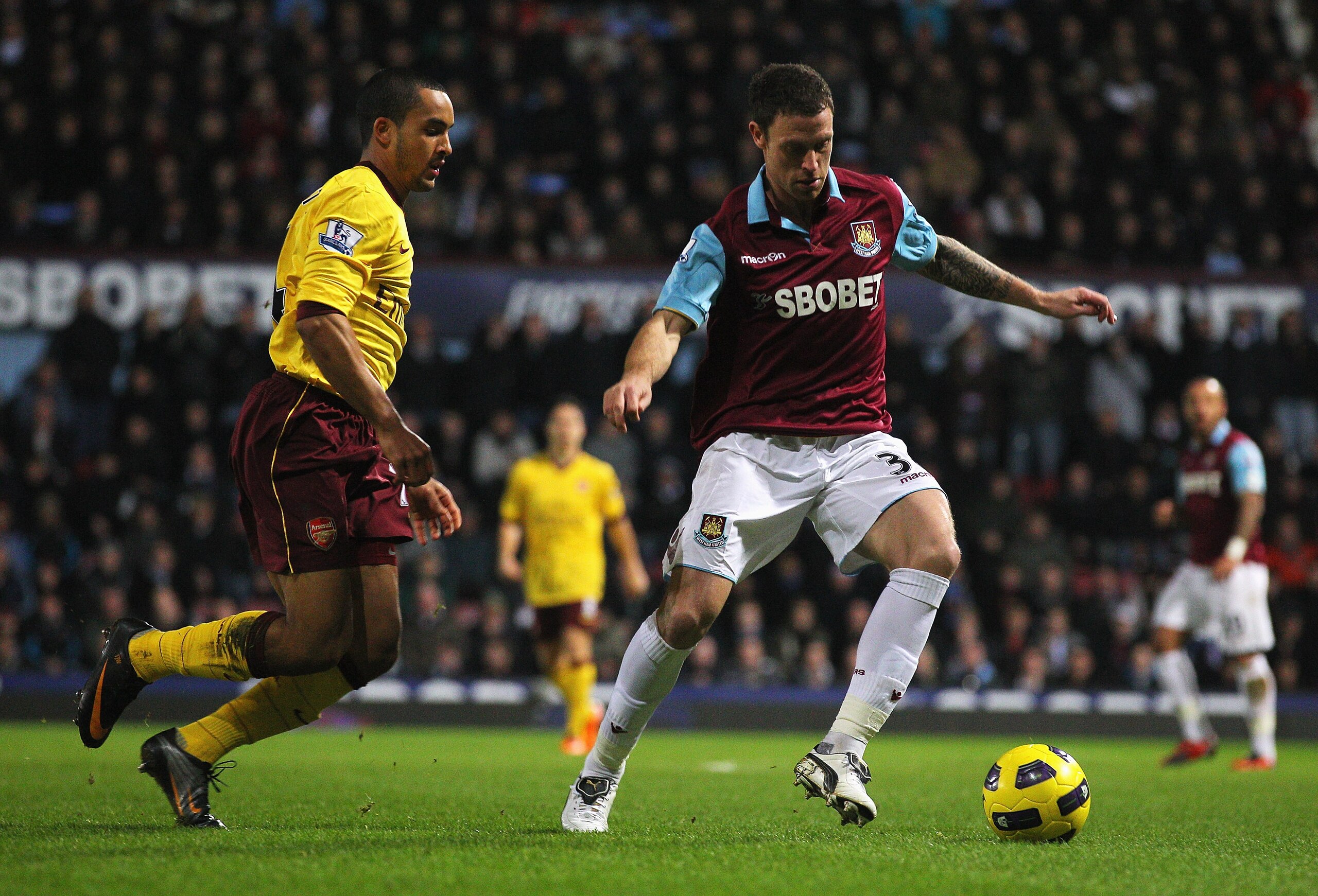 LONDON, ENGLAND - JANUARY 15: Wayne Bridge of West Ham United is closed down by Theo Walcott of Arsenal during the Barclays Premier League match between West Ham United and Arsenal at the Boleyn Ground on January 15, 2011 in London, England.  (Photo by Cl