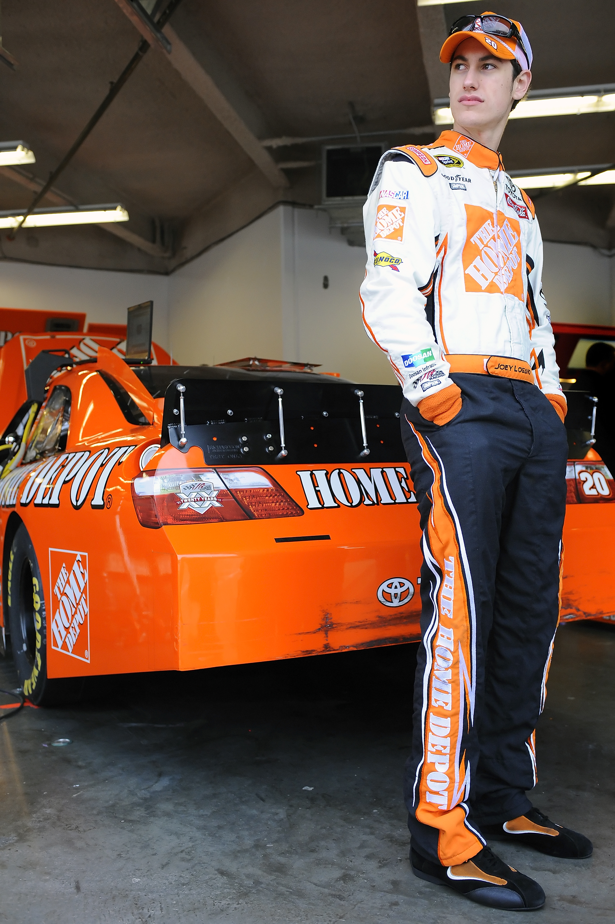 DAYTONA BEACH, FL - JANUARY 22:  Joey Logano, driver of the #20 Home Depot Toyota, stands by his car in the garage area during testing at Daytona International Speedway on January 22, 2011 in Daytona Beach, Florida.  (Photo by Jared C. Tilton/Getty Images