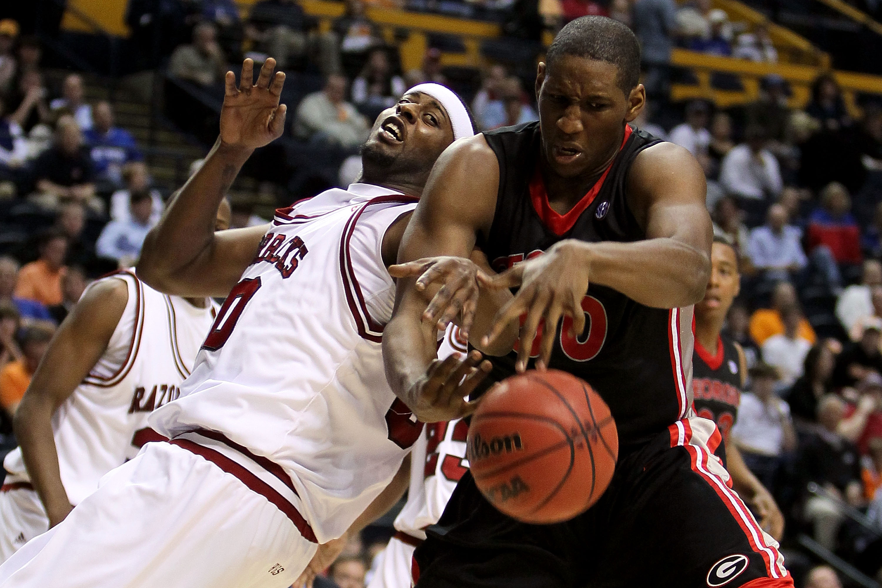 NASHVILLE, TN - MARCH 11: Jeremy Price #50 (R) of the Georgia Bulldogs fights for control of a rebound against Mike Washington #00 of the Arkanasas Razorbacks during the first round of the SEC Men's Basketball Tournament at the Bridgestone Arena on March