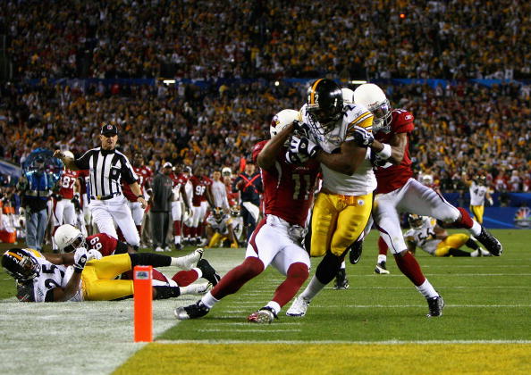 TAMPA, FL - FEBRUARY 01:  James Harrison #92 of the Pittsburgh Steelers scores a touchdown after running back an interception for 100 yards in the second quarter against Larry Fitzgerald #11 and Steve Breaston #15 of the Arizona Cardinals during Super Bow