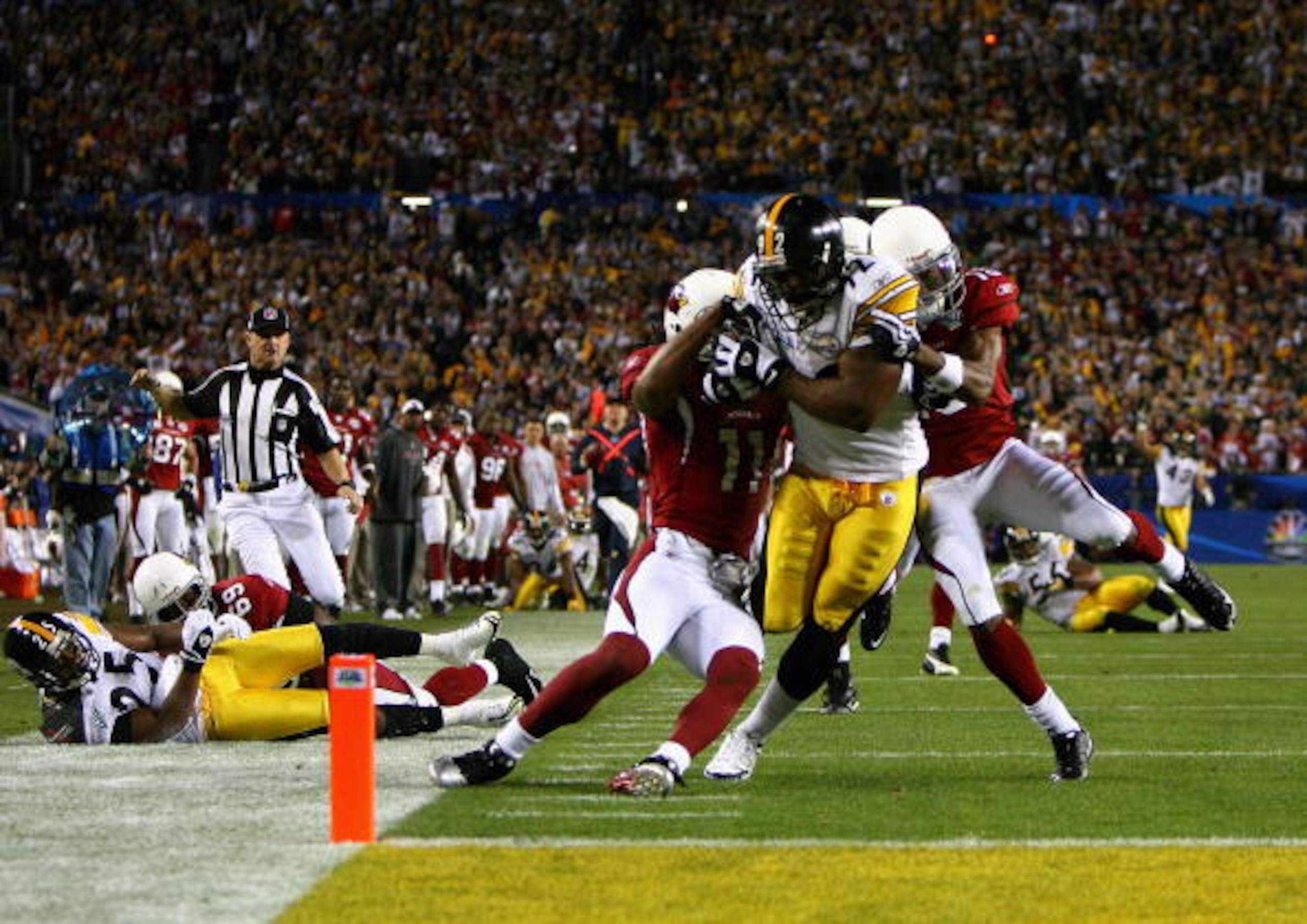 TAMPA, FL - FEBRUARY 01:  James Harrison #92 of the Pittsburgh Steelers scores a touchdown after running back an interception for 100 yards in the second quarter against Larry Fitzgerald #11 and Steve Breaston #15 of the Arizona Cardinals during Super Bow