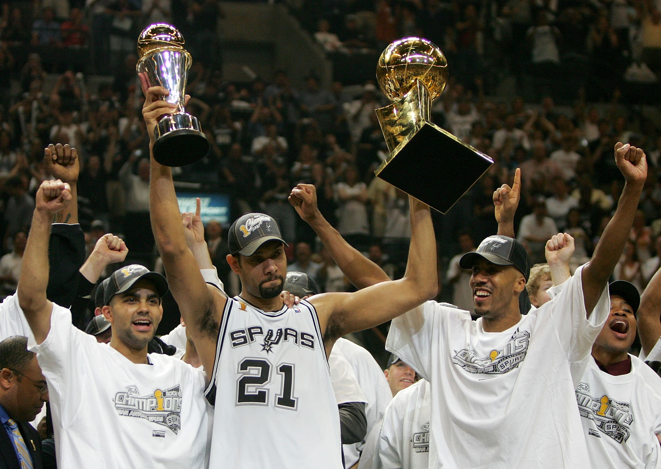 SAN ANTONIO - JUNE 23:  Tim Duncan #21, center, holds up the Finals MVP trophy and the Larry O'Brien trophy as teammates Tony Parker #9, left, and Bruce Bowen #12 of the San Antonio Spurs celebrate after defeating the Detroit Pistons in Game seven of the