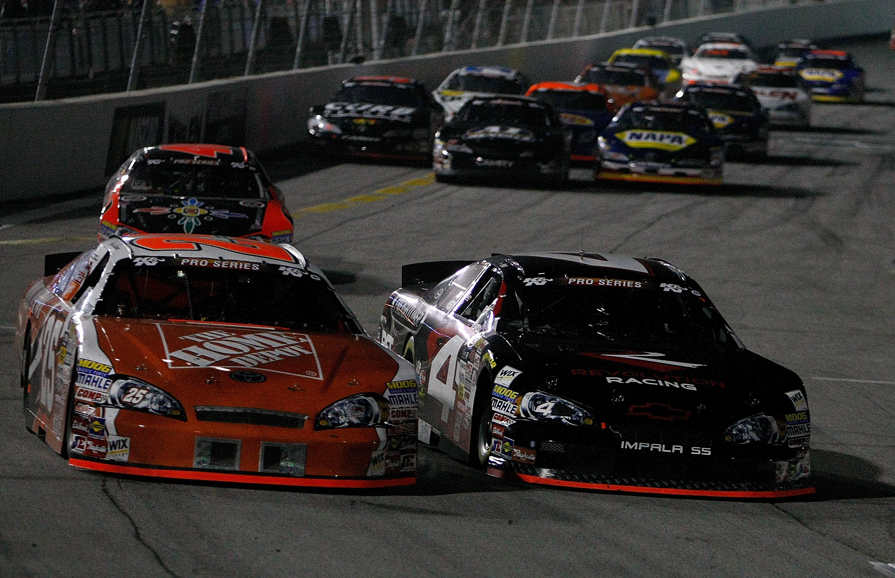 IRWINDALE, CA - JANUARY 30:  Joey Logano driver of the #25 Home Depot Toyota battles Sergio Pena in the #4 Revolution Racing Chevrolet during  the NASCAR Toyota All-Star Showdow at Toyota Speedway  on January 30, 2010 in Irwindale, California.  (Photo by