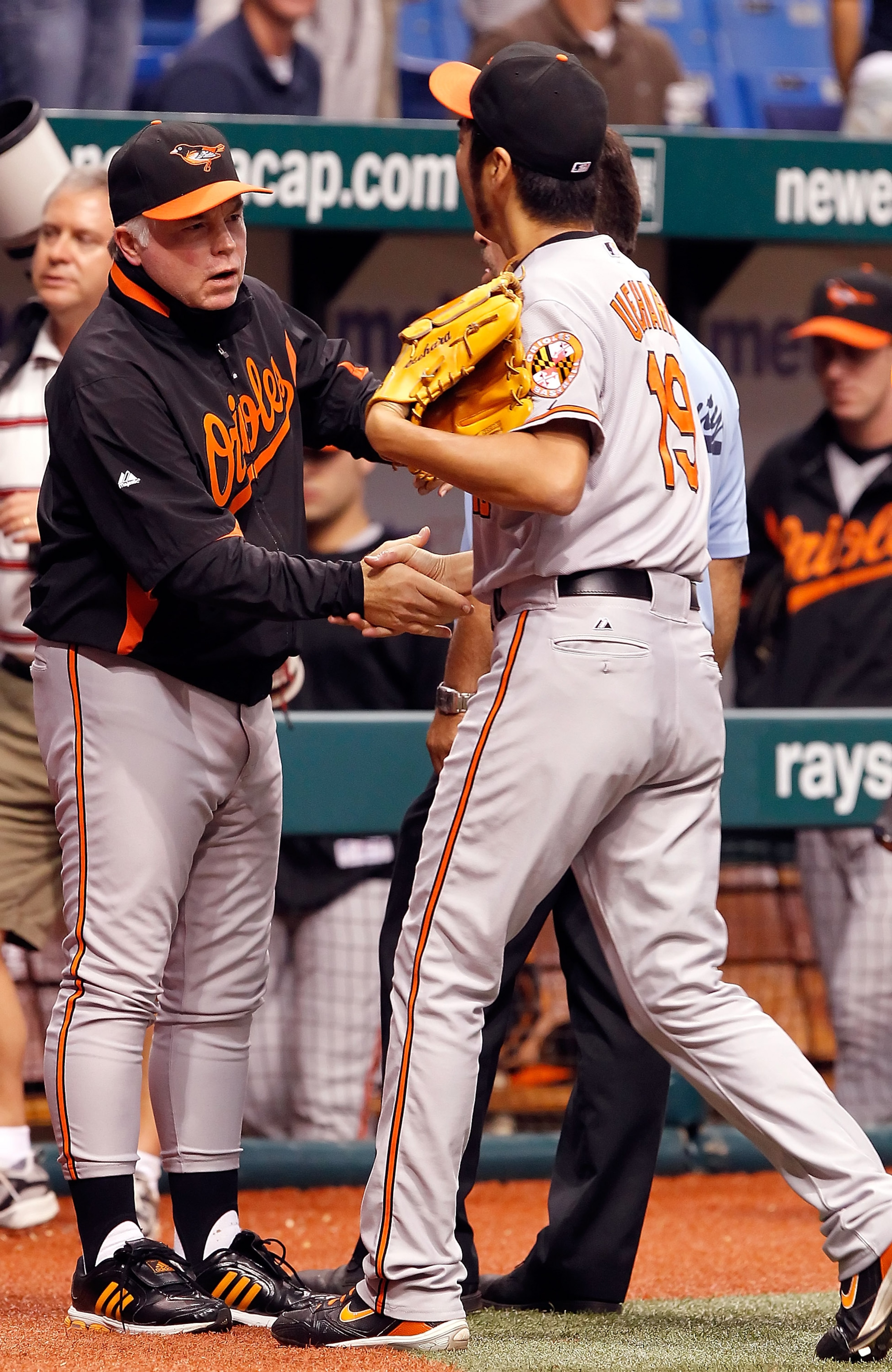 ST. PETERSBURG, FL - SEPTEMBER 29:  Manager Buck Showalter of the Baltimore Orioles congratulates relief pitcher Koji Uehara #19 for his save against the Tampa Bay Rays at Tropicana Field on September 29, 2010 in St. Petersburg, Florida.  (Photo by J. Mer